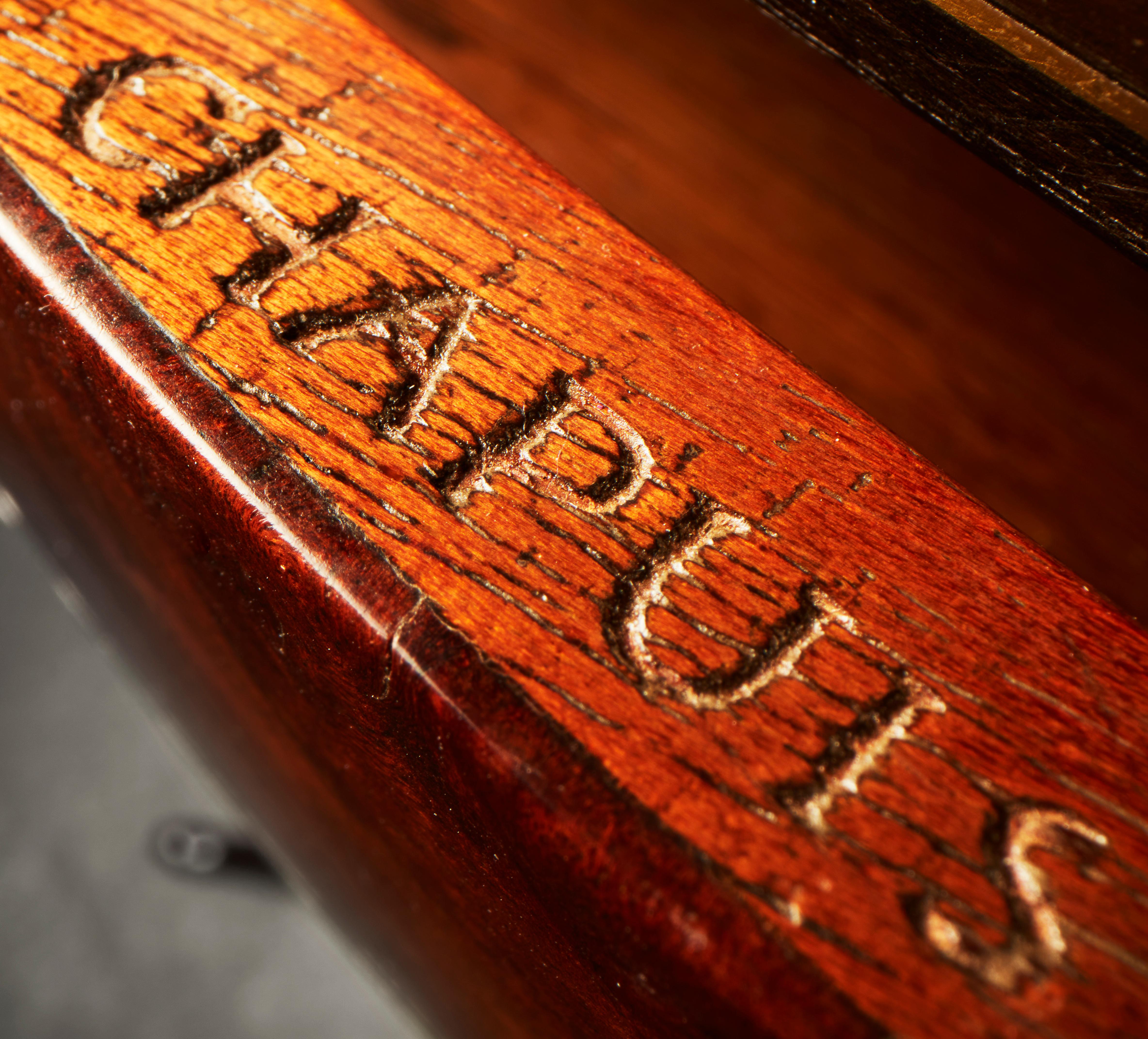 Il piano ovale con inserto in marmo grigio sovrasta un unico cassetto a fregio, con intarsio di linee e stelle in ottone, sollevato su sottili gambe ricurve unite da un sottopiano ovale, che terminano su piedini a ciabatta; all'interno del cassetto