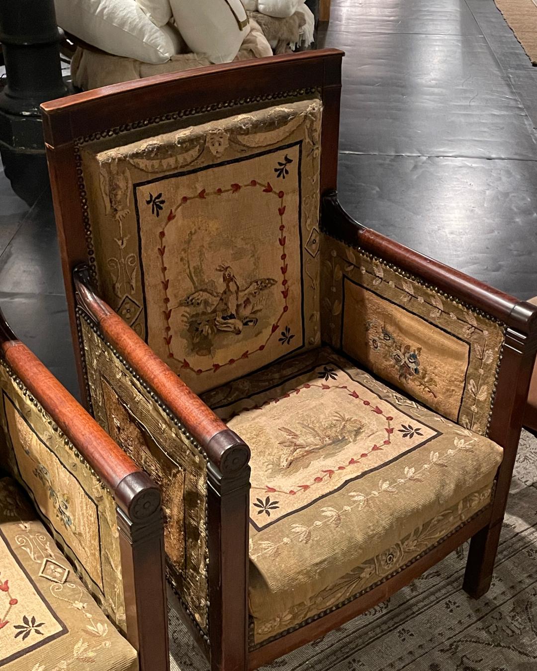 Immerse yourself in the captivating allure of a pair of French Empire armchairs from 1810. Fashioned in rich mahogany, these exquisite chairs epitomize the Empire style, boasting upholstered backs, seats, and arms adorned with the original tapestry