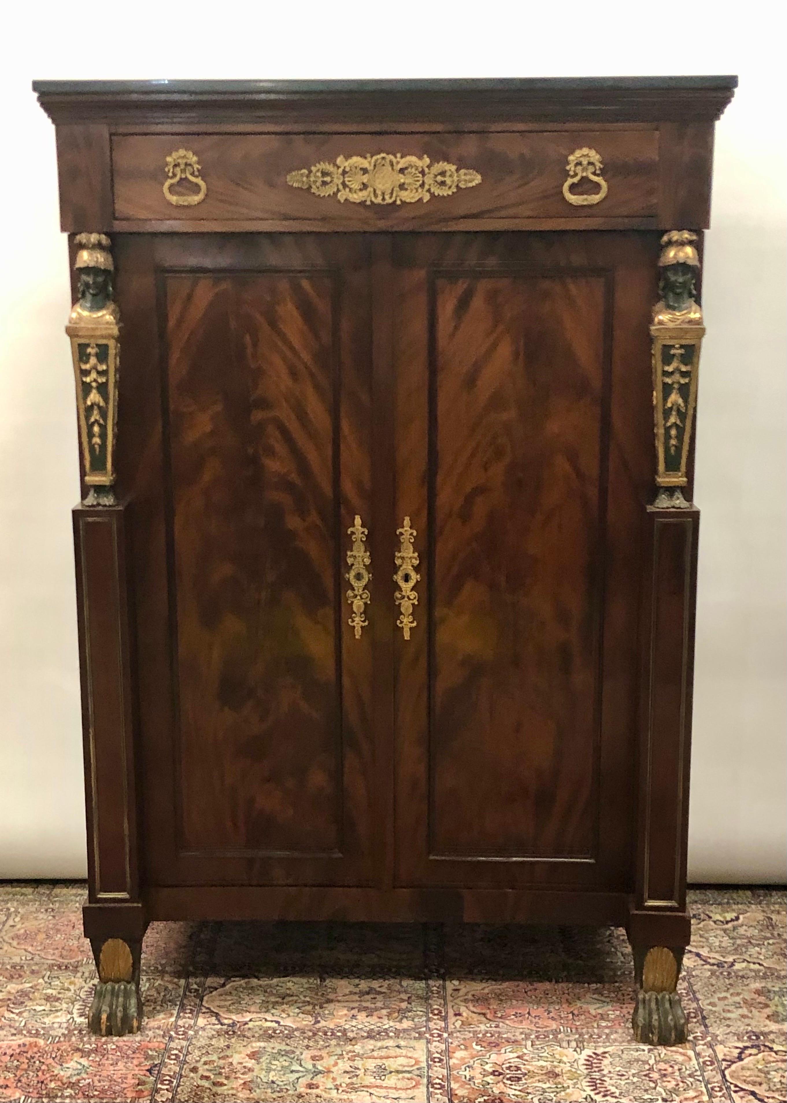 Impressive French Empire Egyptian Revival Gentleman's Cabinet / Chest with carved Caryatides Soldier Motifs on Paw Feet was made in the early 19th Century. This Elegant French Empire Gentleman's Cabinet has beautiful Flame Mahogany Veneered Wardrobe