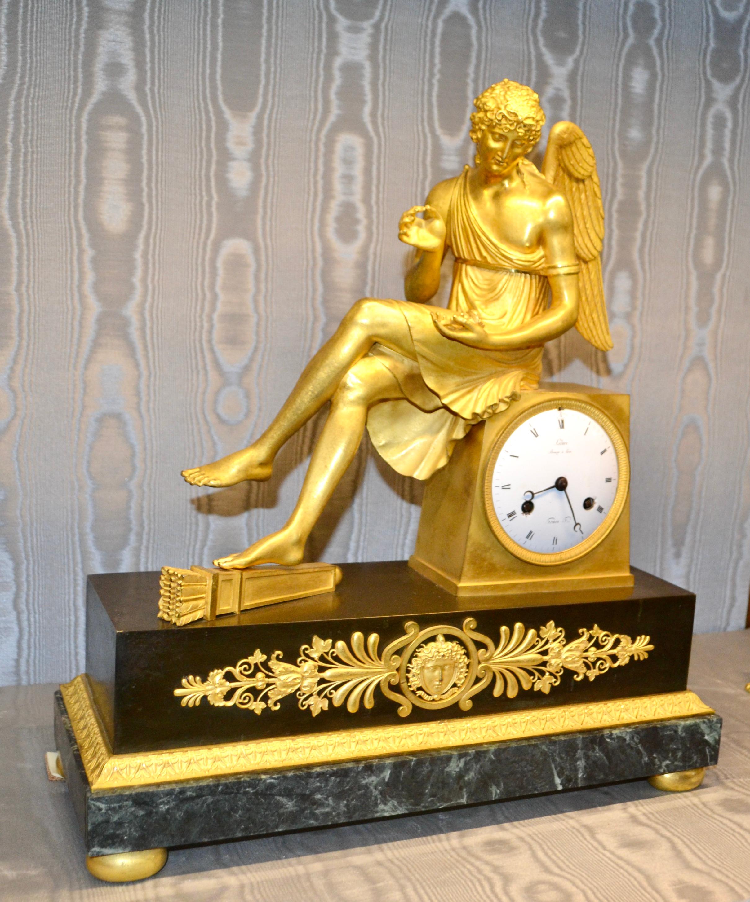 Horloge Empire française en bronze doré et marbre représentant Cupidon assis tenant une rose en vente 4