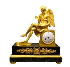 Horloge Empire française en bronze doré et marbre représentant Cupidon assis tenant une rose