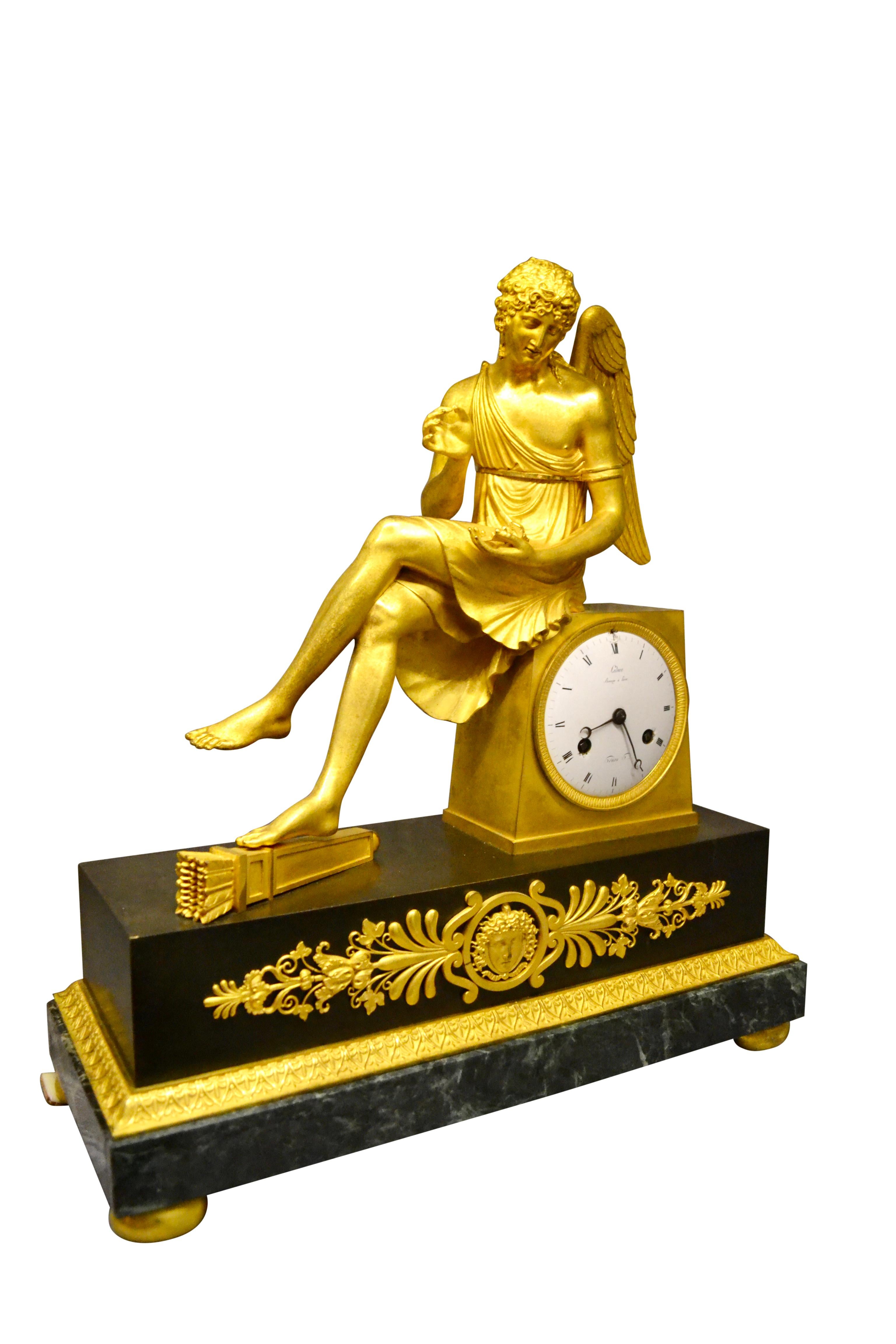 Français Horloge Empire française en bronze doré et marbre représentant Cupidon assis tenant une rose en vente