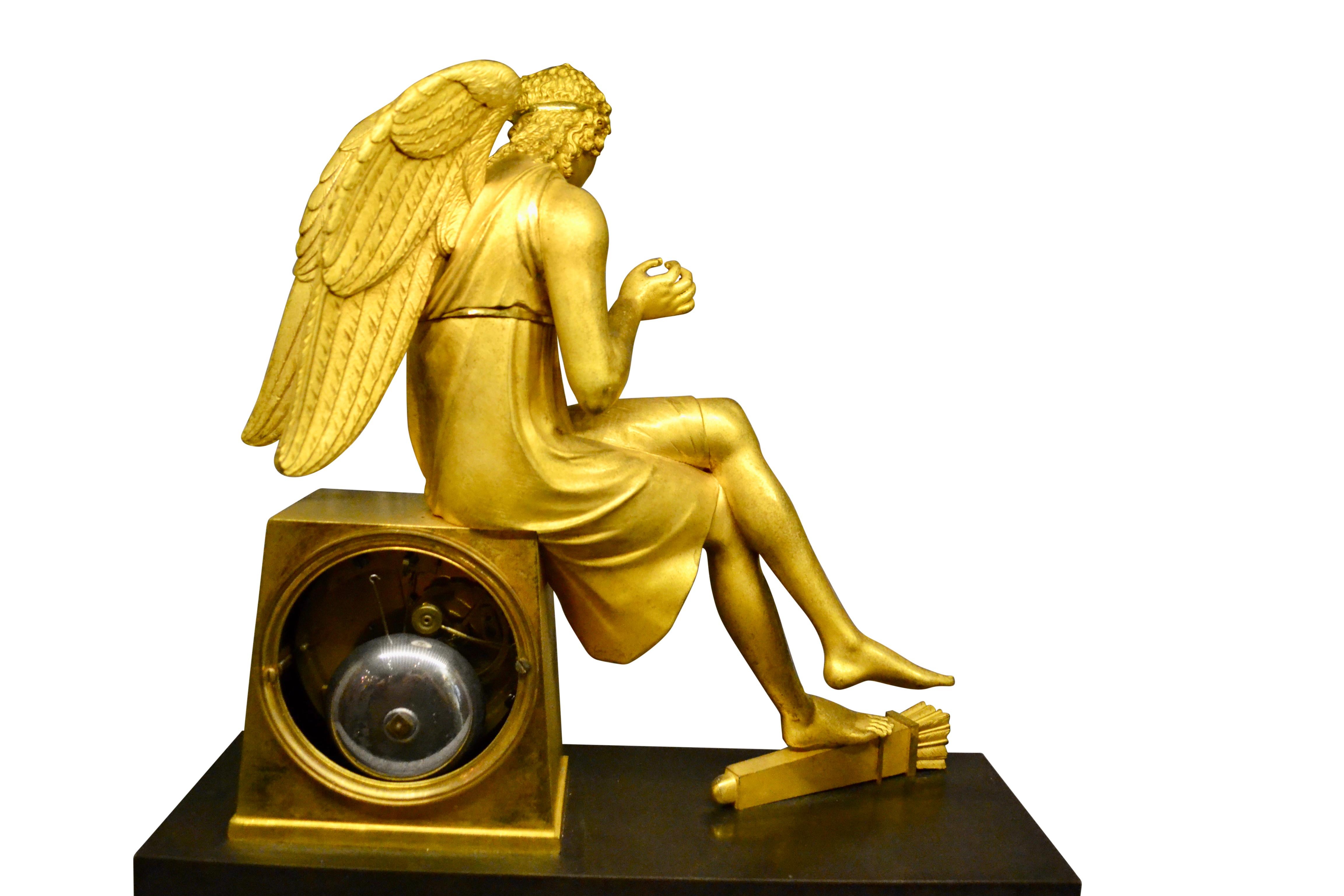 Doré Horloge Empire française en bronze doré et marbre représentant Cupidon assis tenant une rose en vente