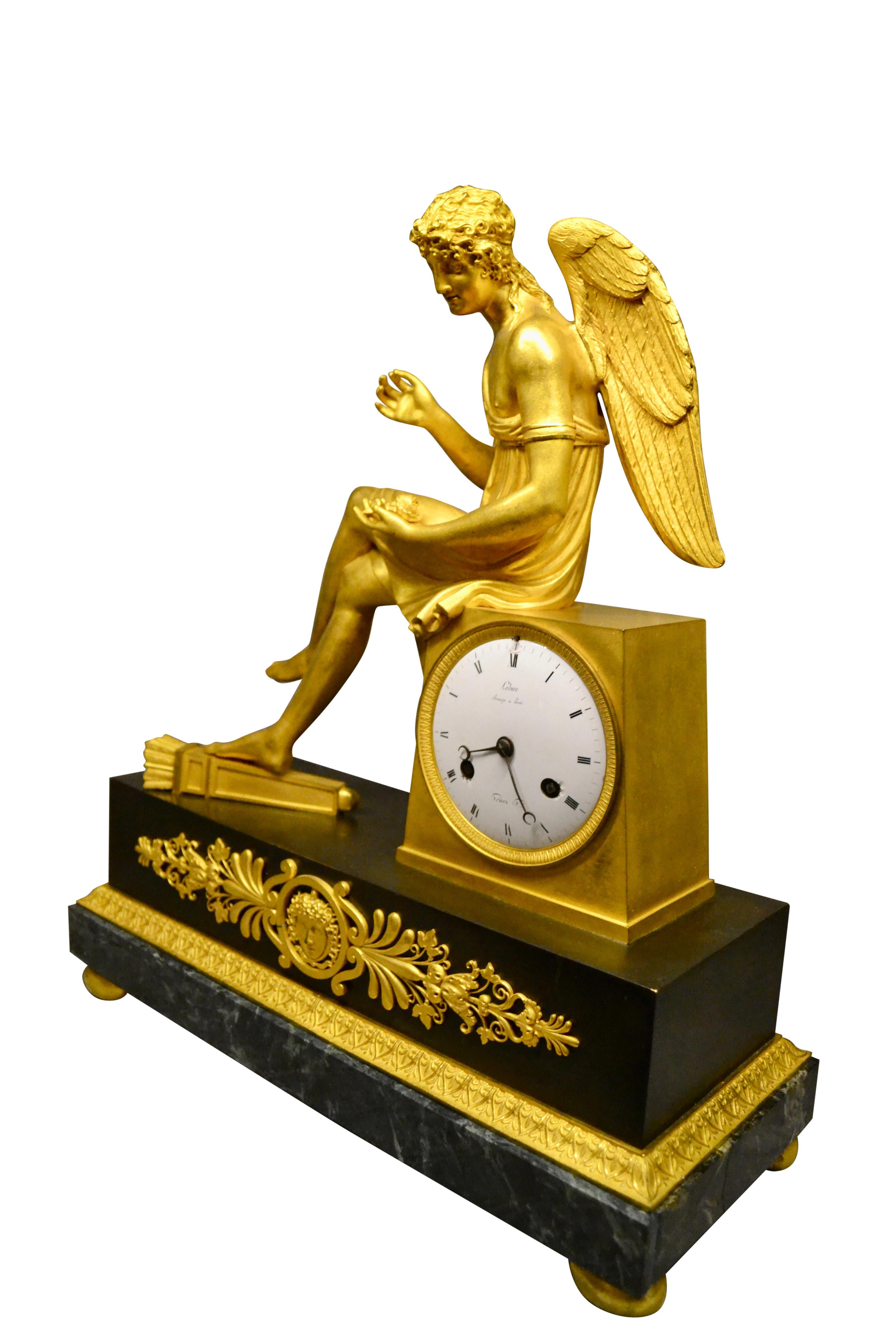 Bronze Horloge Empire française en bronze doré et marbre représentant Cupidon assis tenant une rose en vente