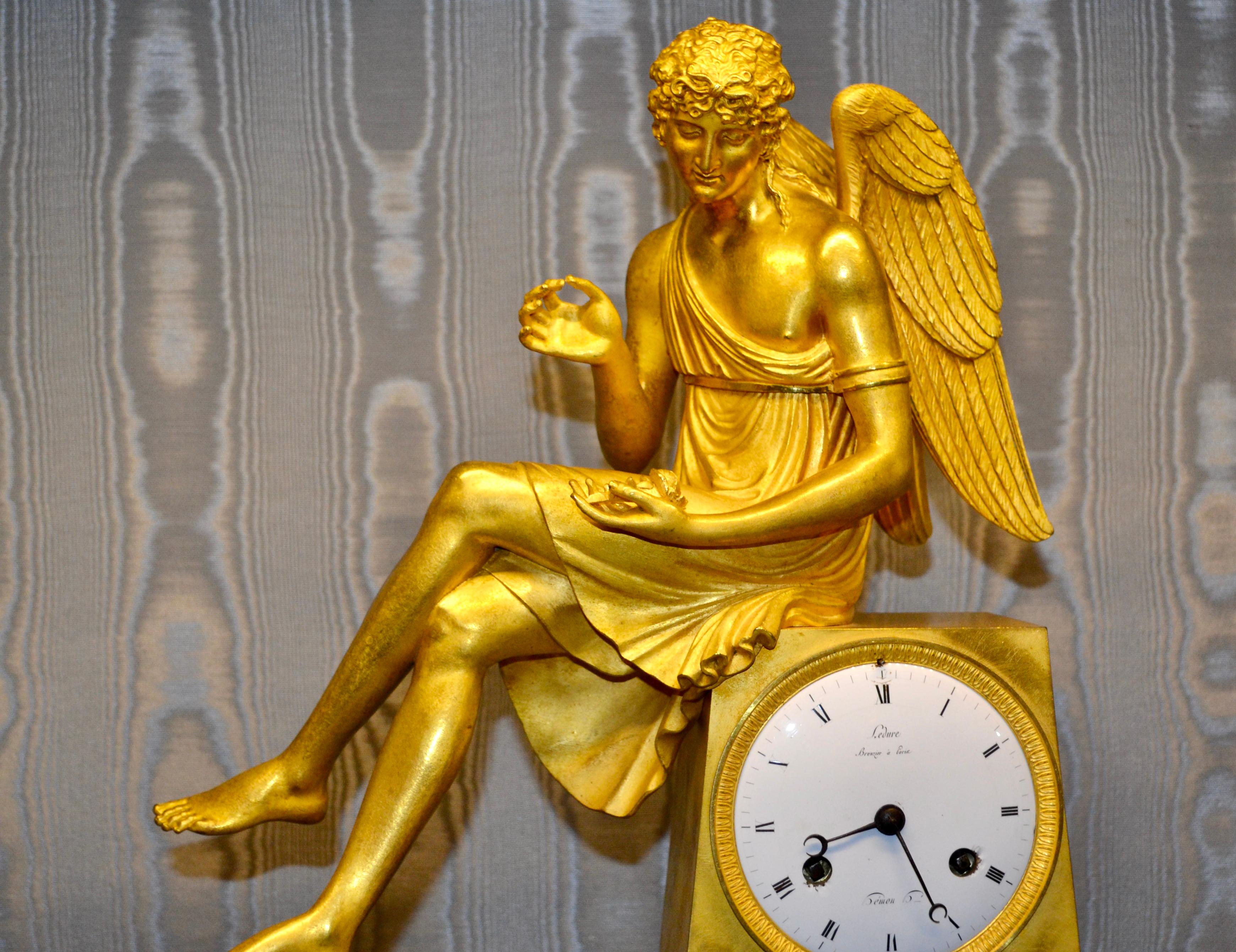Horloge Empire française en bronze doré et marbre représentant Cupidon assis tenant une rose en vente 2