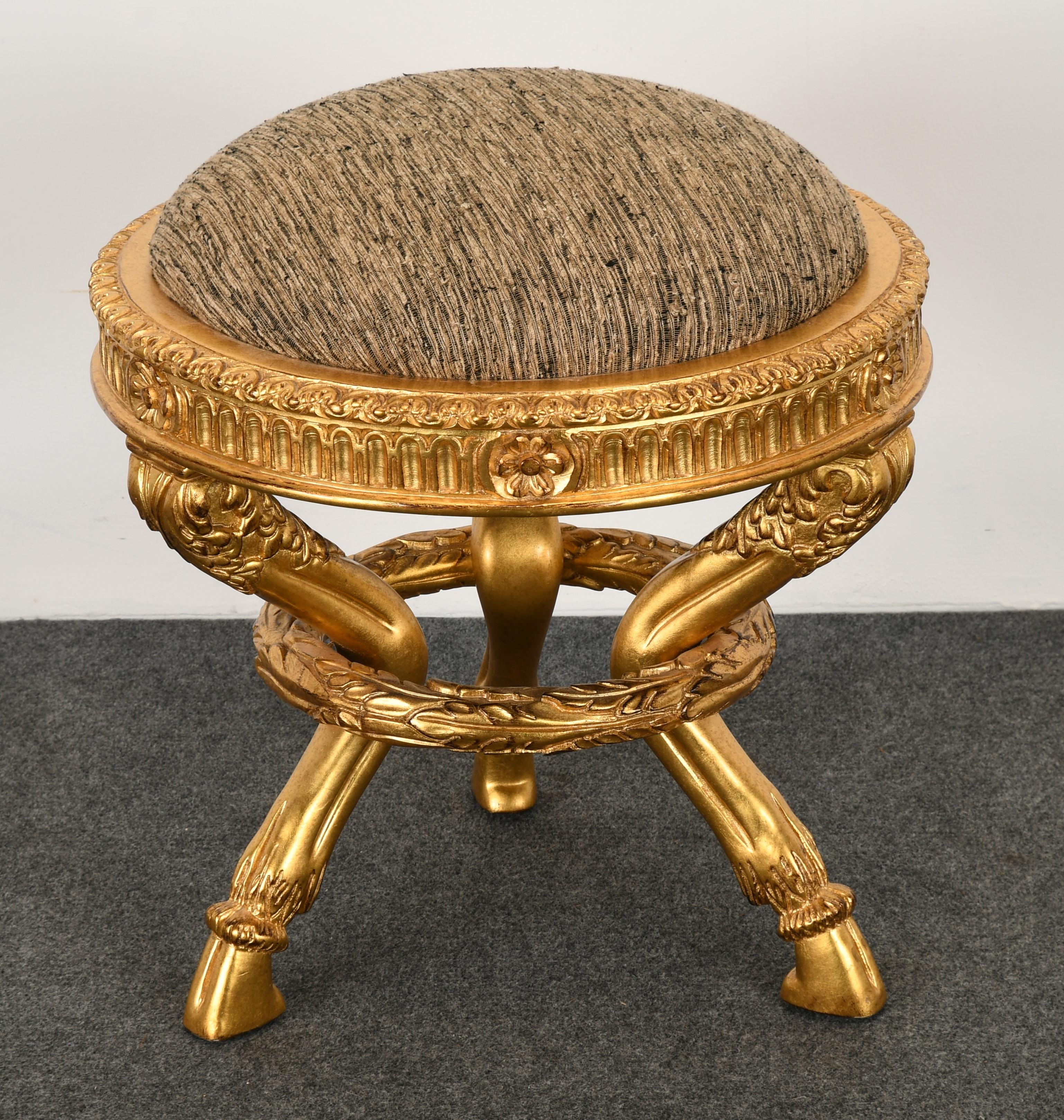 A unique giltwood footstool with hoof feet and garland design. Inspired by French and Italian Empire-style antiques. This bench would make a great accent piece in any room. The ottoman is in the manner of the store in California 