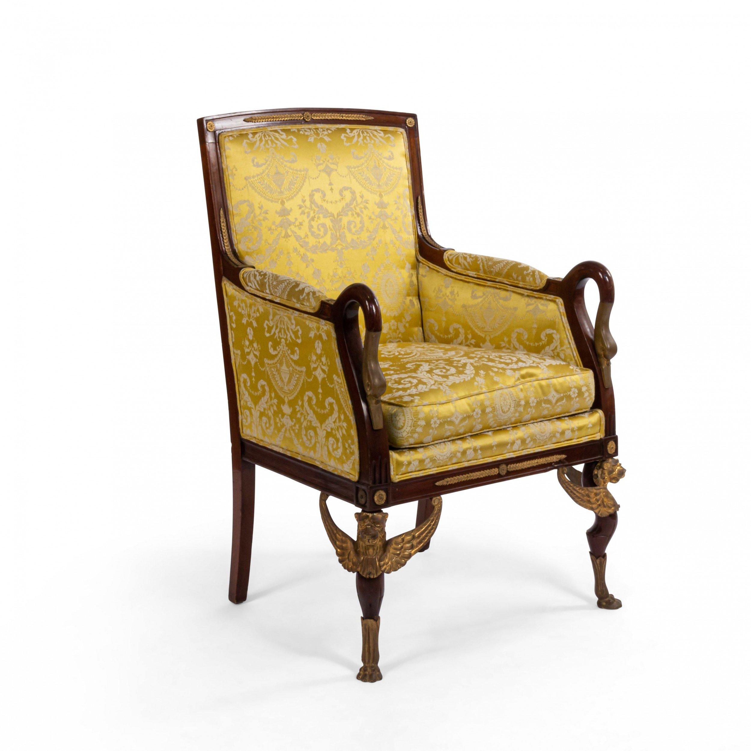 Pair of French Empire style (19th century) mahogany swan design Bergère armchairs with bronze trim, griffin legs, and gold upholstery.