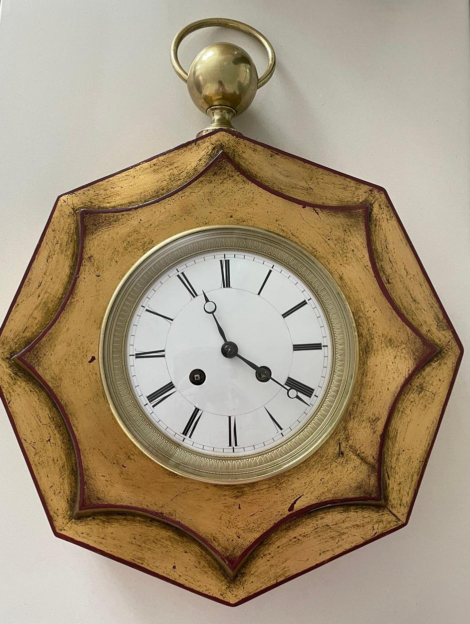 Une grande et rare horloge murale ancienne à tole plaquée or, Empire, France, vers 1820. 

Mouvement Japy Frères huit jours avec pendule à corde et sonnerie horaire/demi-horaire sur cloche.

Le mouvement a été révisé par notre horloger qualifié et