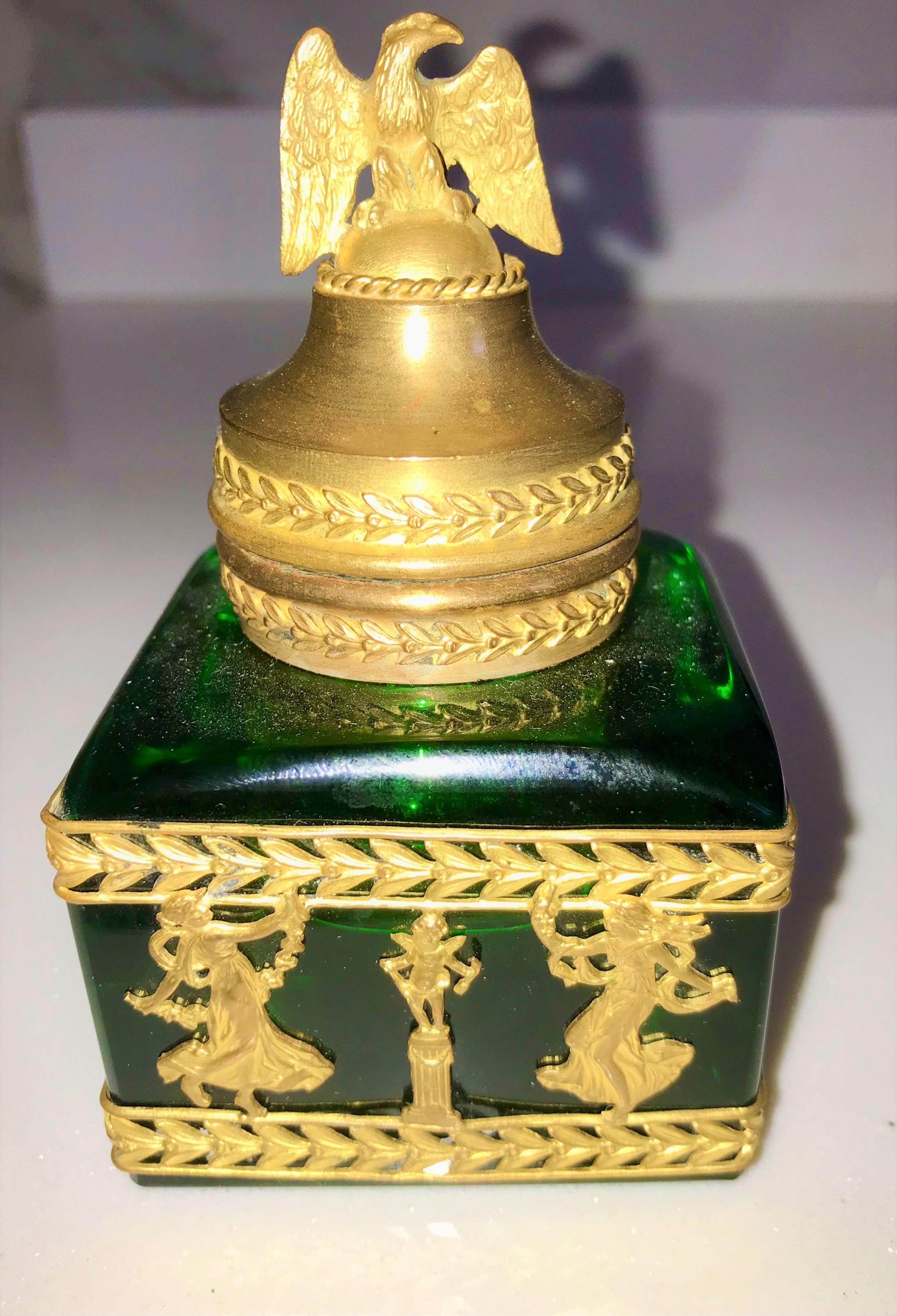 Emerald green glass mounted inkwell with ormolu frieze of laurels, demigods and an eagle (lid). minor wear, interior ink reservoir chipped. Minor wear to gilding. 

Good overall condition , light wear to gilding .Typical age issues .
 