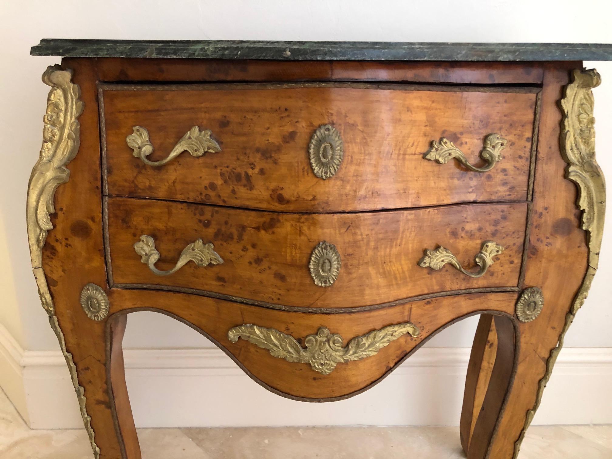 Sumptuous burl wood Louis XV style two-drawer commode with beautiful
Bombe front and sides as well as fancy Ormolu bronzes on the front edges, apron, drawer pulls, key holes and feet sabots. Elegant green and cream veined marble
