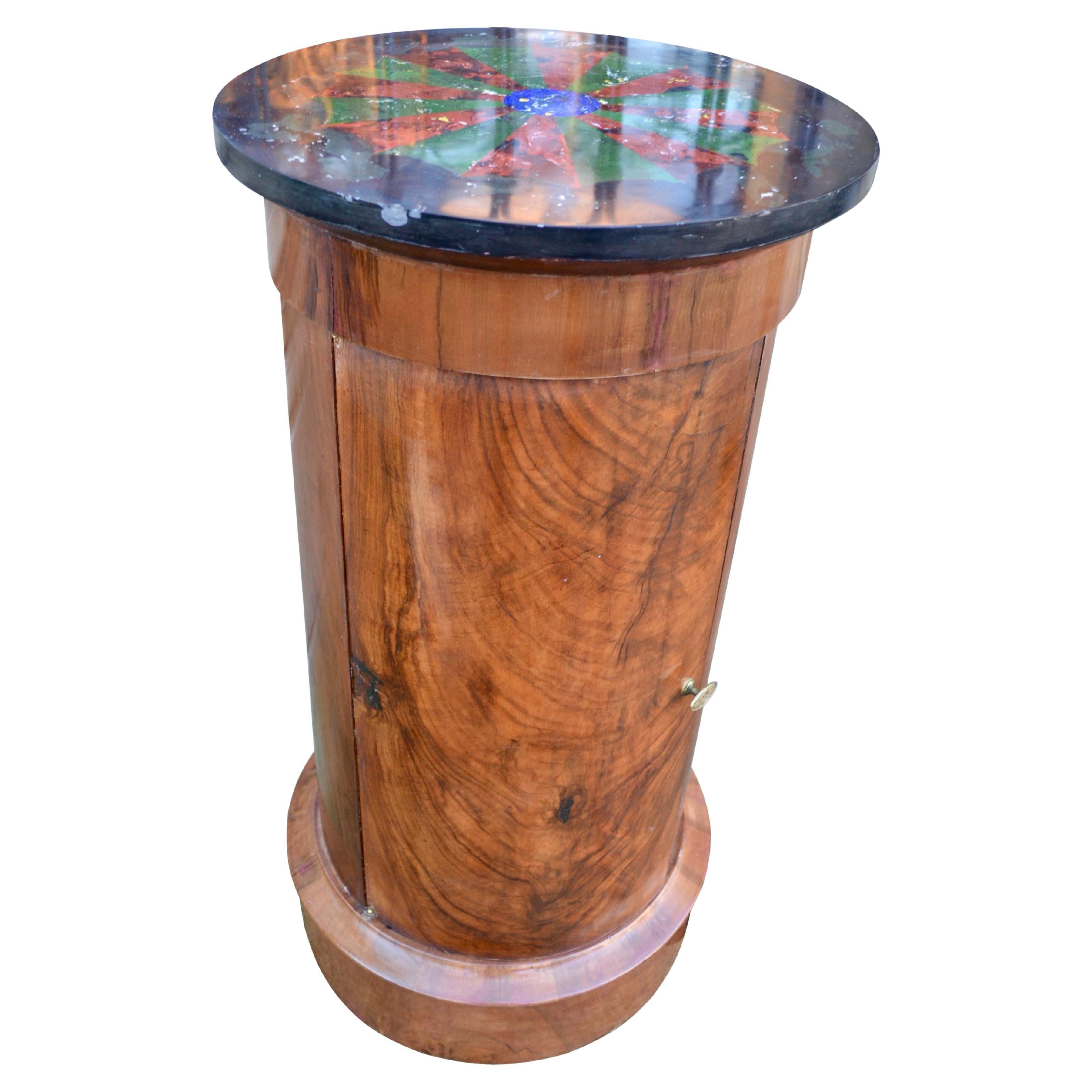 A classically inspired French Empire marble topped mahogany bedside table which the french call sono. fThe round column shaped table has a black marble top with a recently applied geometric scagliola pattern.. The table sits on a raised round base.