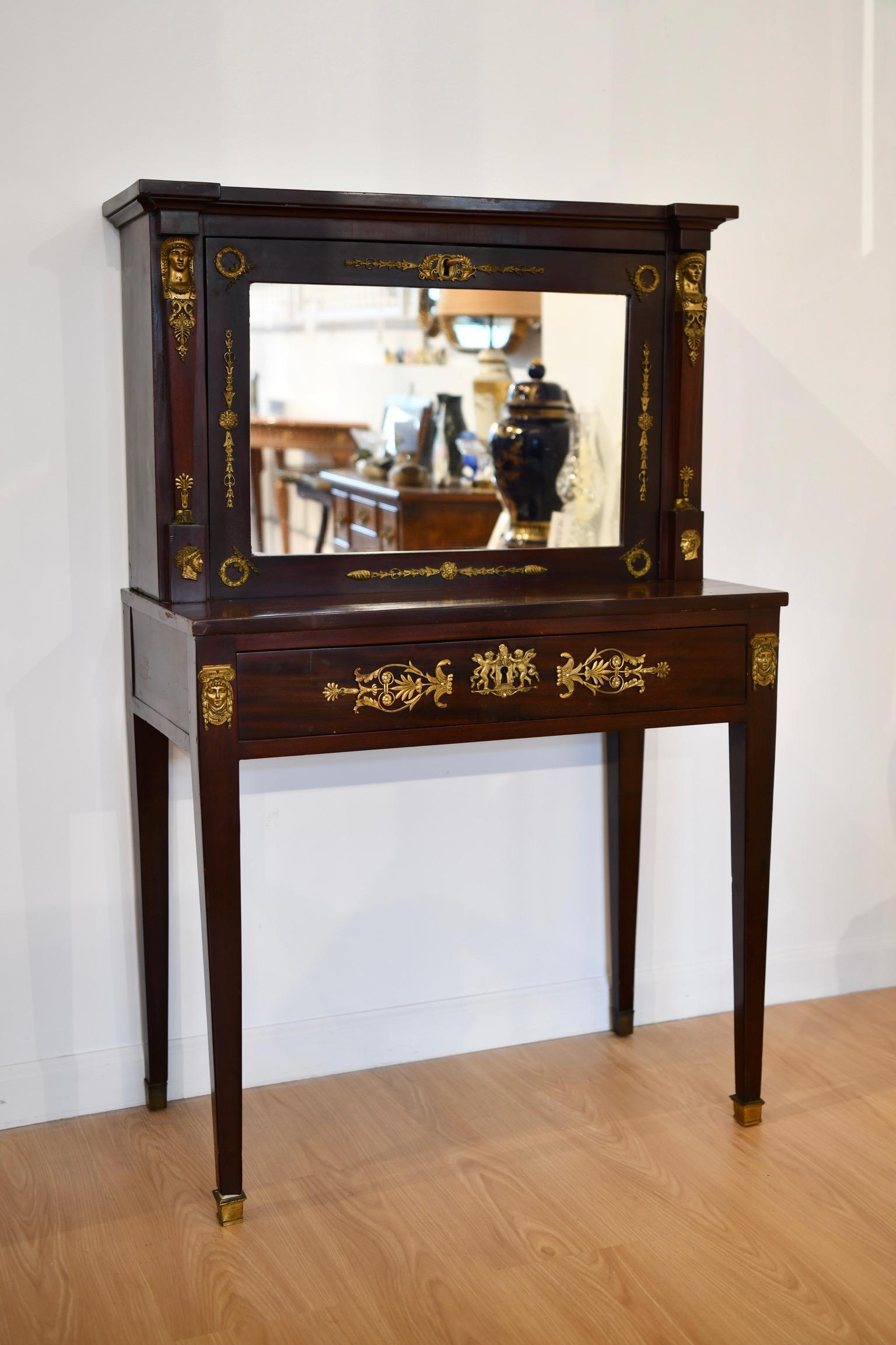19th century French Empire mahogany Bonheur du Jour desk. The upper section is decorated with classical motifs of pharaoh masks and wreaths around a mirrored secretary fall-front with compartments and a writing pad over the lower section. Bottom