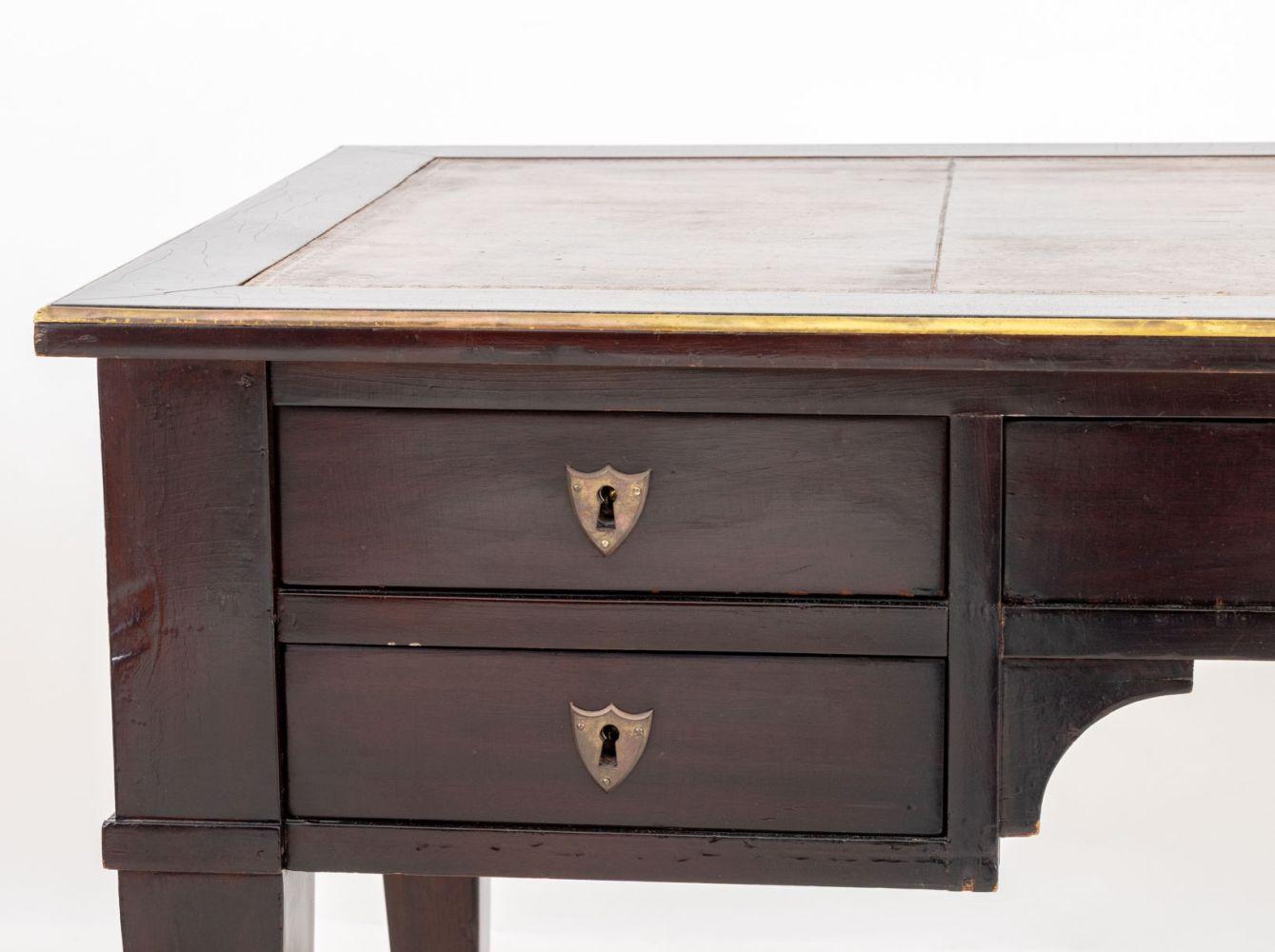 Französisch Empire Mahagoni Bureau Plat, 19. Jahrhundert, mit vergoldeten tan Leder oben mit zentralen Fries Schublade flankiert von zwei kurzen Schubladen auf jeder Seite mit faux Partner Schreibtisch zurück auf vier konische Beine.

30