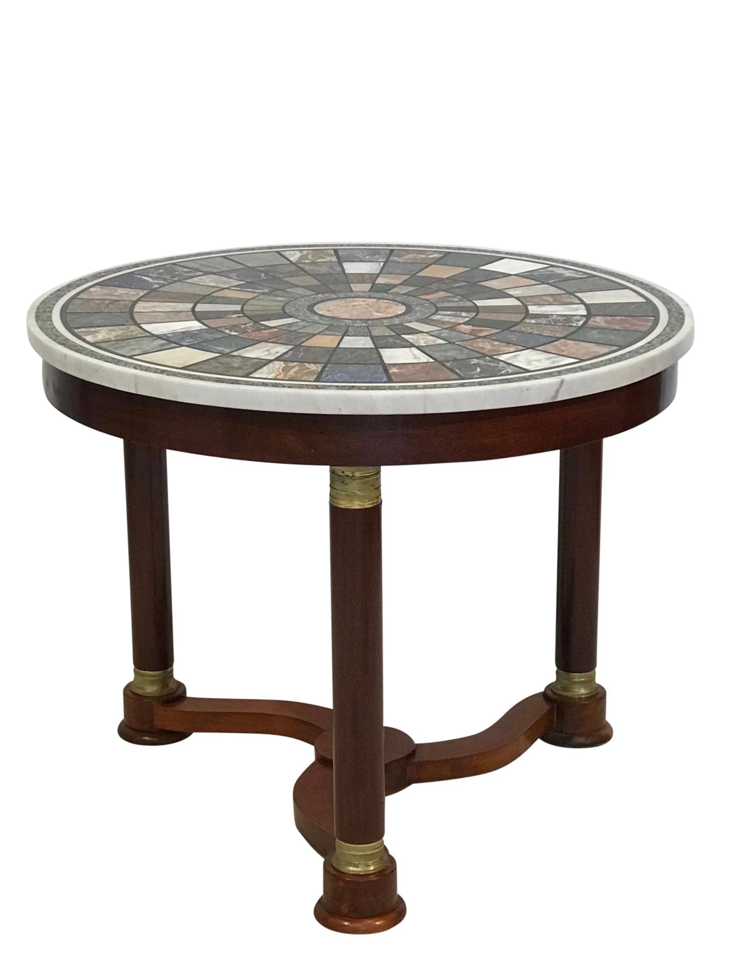 Handsome mahogany round center table with brass mounts on the legs and a multi-stone specimen top.
France, early to mid-19th century.