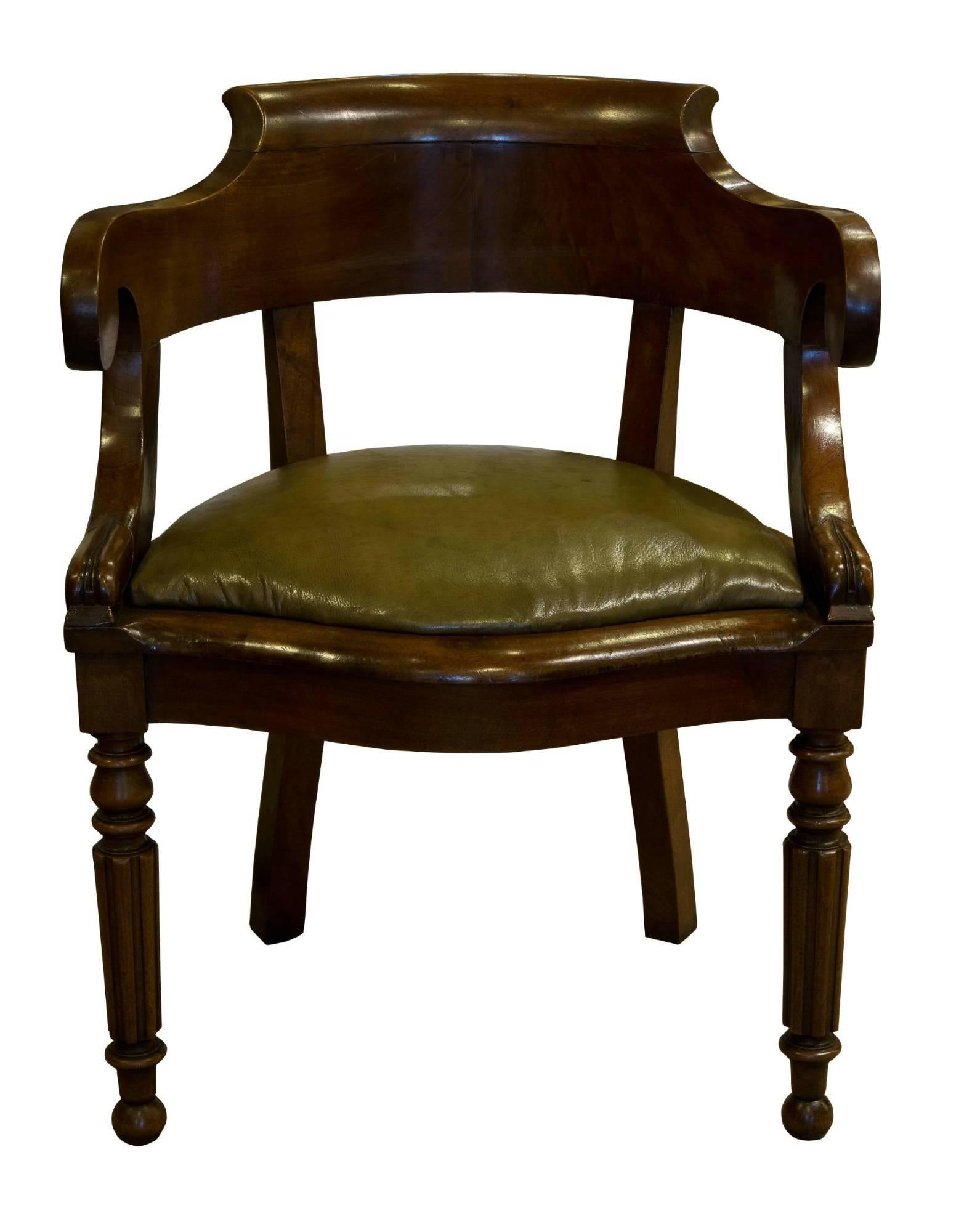 A French Empire mahogany desk chair of horseshoe form. Standing on fluted legs and with green hide covered seat. 


circa 1840.