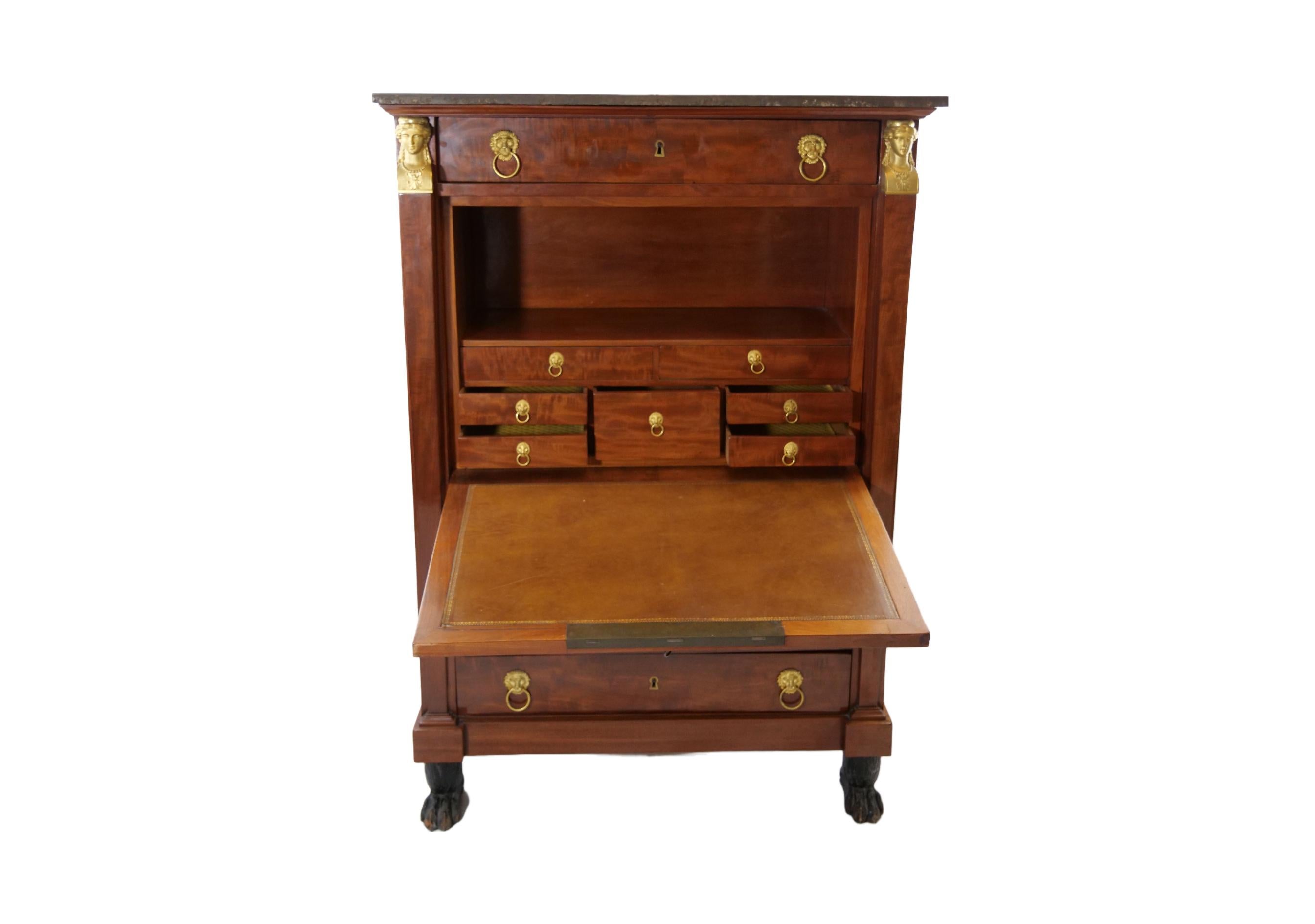 Early 19th century French mahogany wood Empire style drop front secretary with a removable black marble top. The secretary features two front side columns with bronze mounts detail with three pull drawers below and one drawer above resting on four