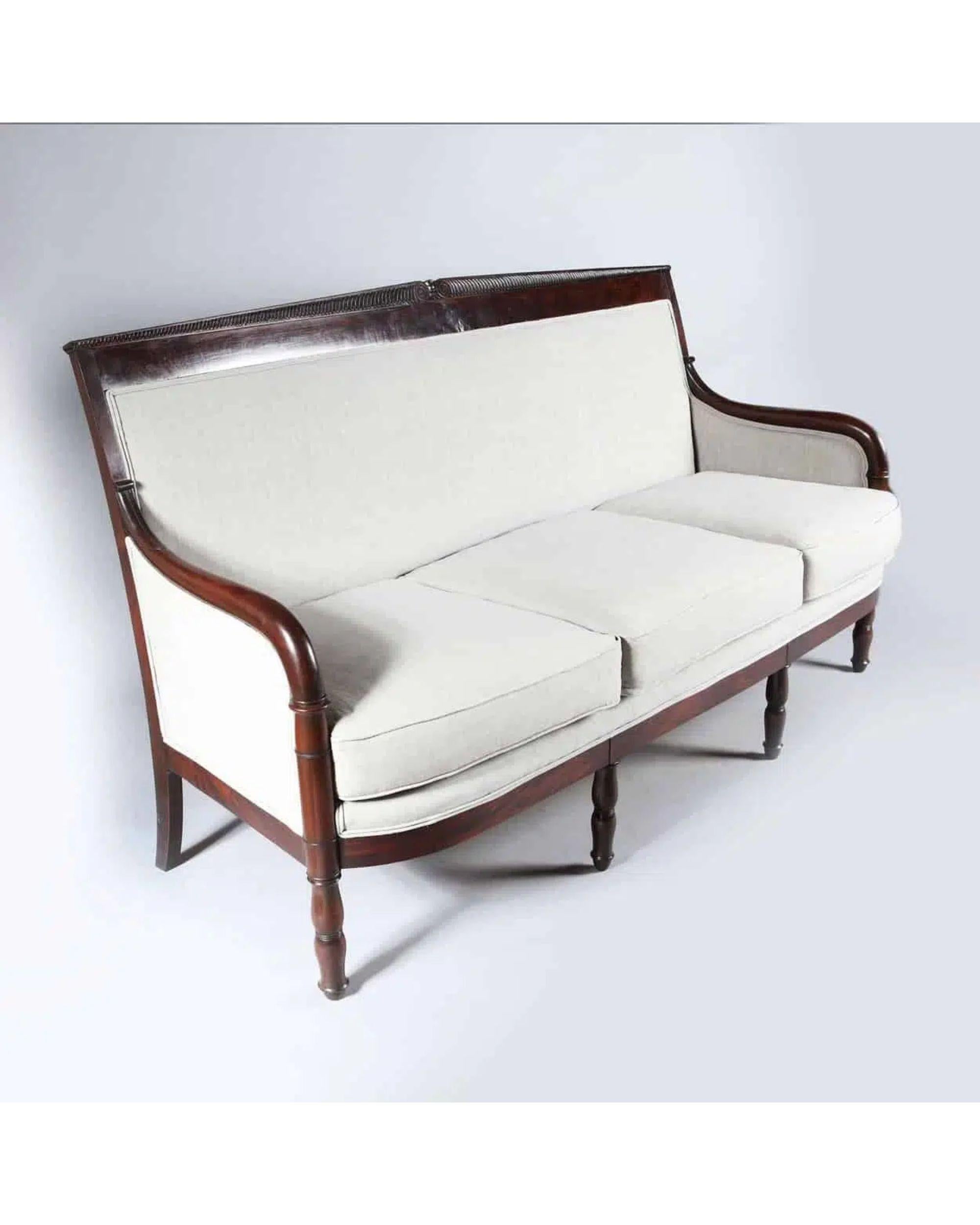 Early 19th Century French Empire Mahogany Settee

An Empire finely carved dark figured mahogany three seat settee, the back is surmounted by facing scrolls with strigilated flutes below. The settee stand on turned double baluster legs at the front