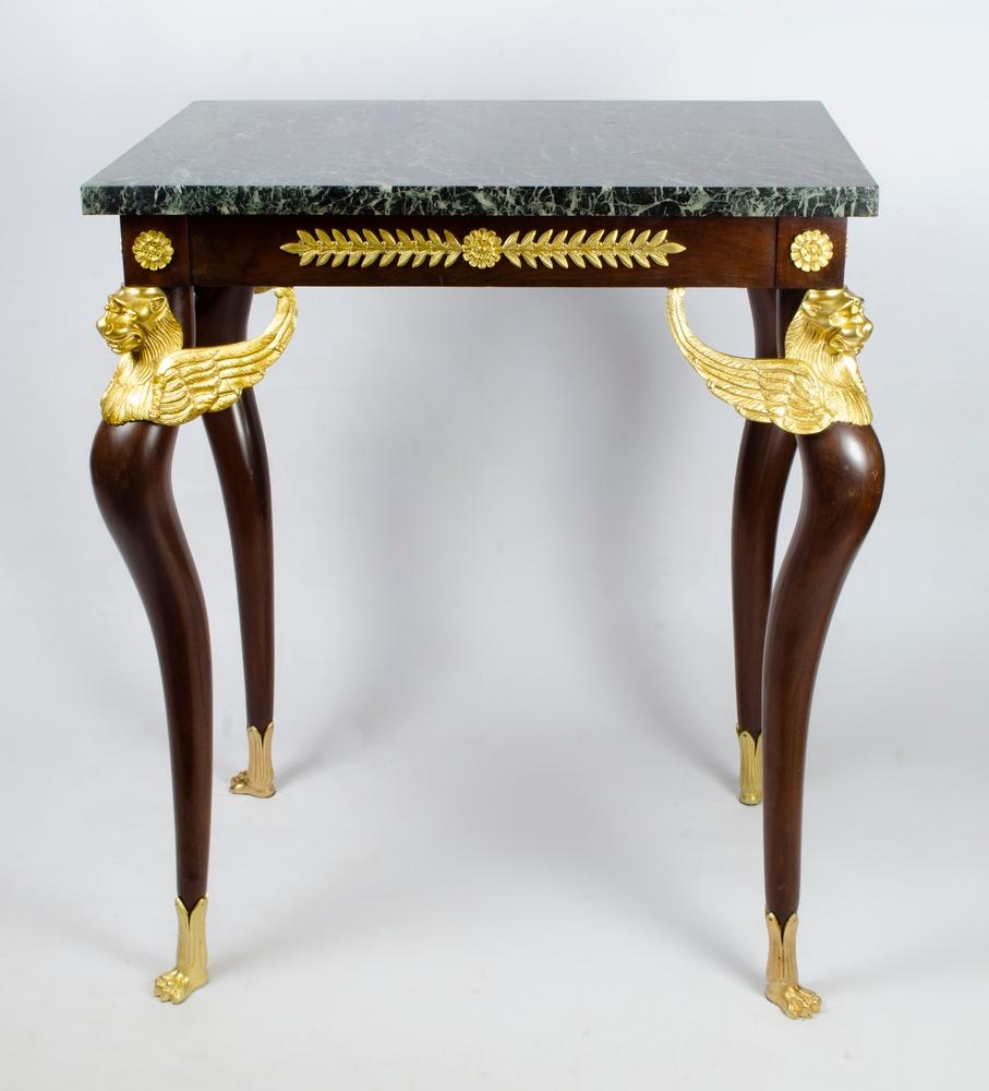 French Empire-style (19th century) mahogany end/center table with bronze trim and winged griffins on legs with a green rectangular marble top.

Empire
A period of design during the reign of Napoleon I. It was most prevalent between 1800 and the
