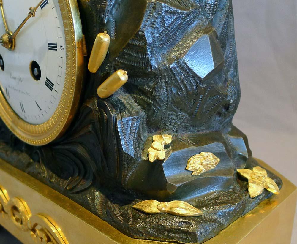 exceptionnellement rare horloge de cheminée Empire française de deux cupidons signée Coeur fils Rue St Honoré No 140 a Paris. Cette petite horloge de cheminée d'une qualité exceptionnelle date de 1811. Il repose sur quatre pieds toupies en bronze