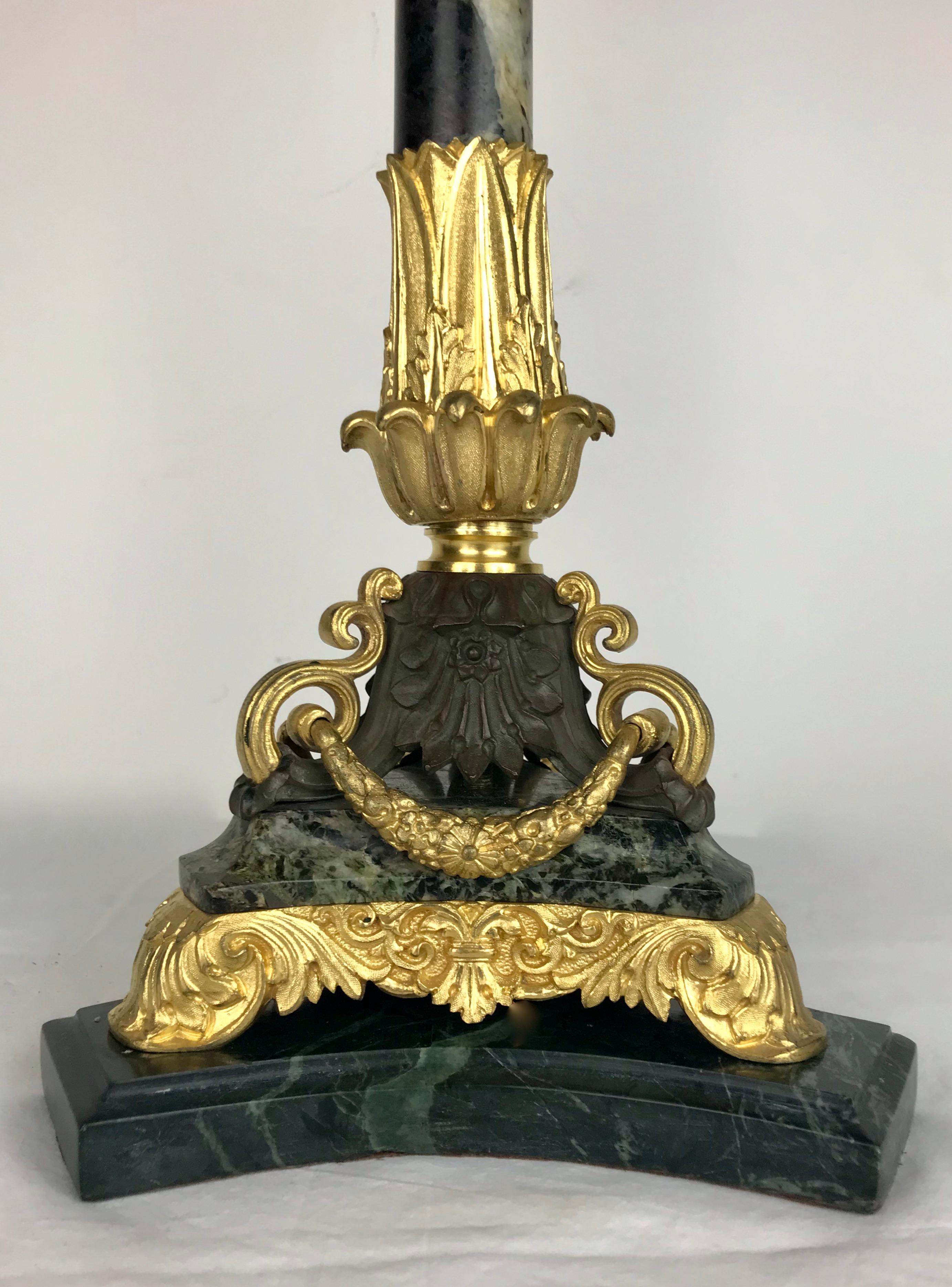 Questa pregiata base per lampada in bronzo e marmo verde del XIX secolo ha una forma colonnare. Presenta motivi neoclassici, tra cui volute floreali e foglie d'acanto.