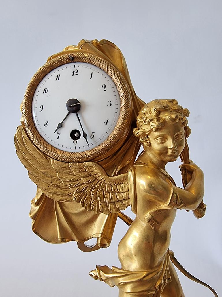 Fabulous antique French Empire miniature mantel clock of Cupid carrying off time. This has to be one of my all time favourite French Empire mantel clocks. Entirely original fire gilded mercury ormolu, on the model which is usually attributed to