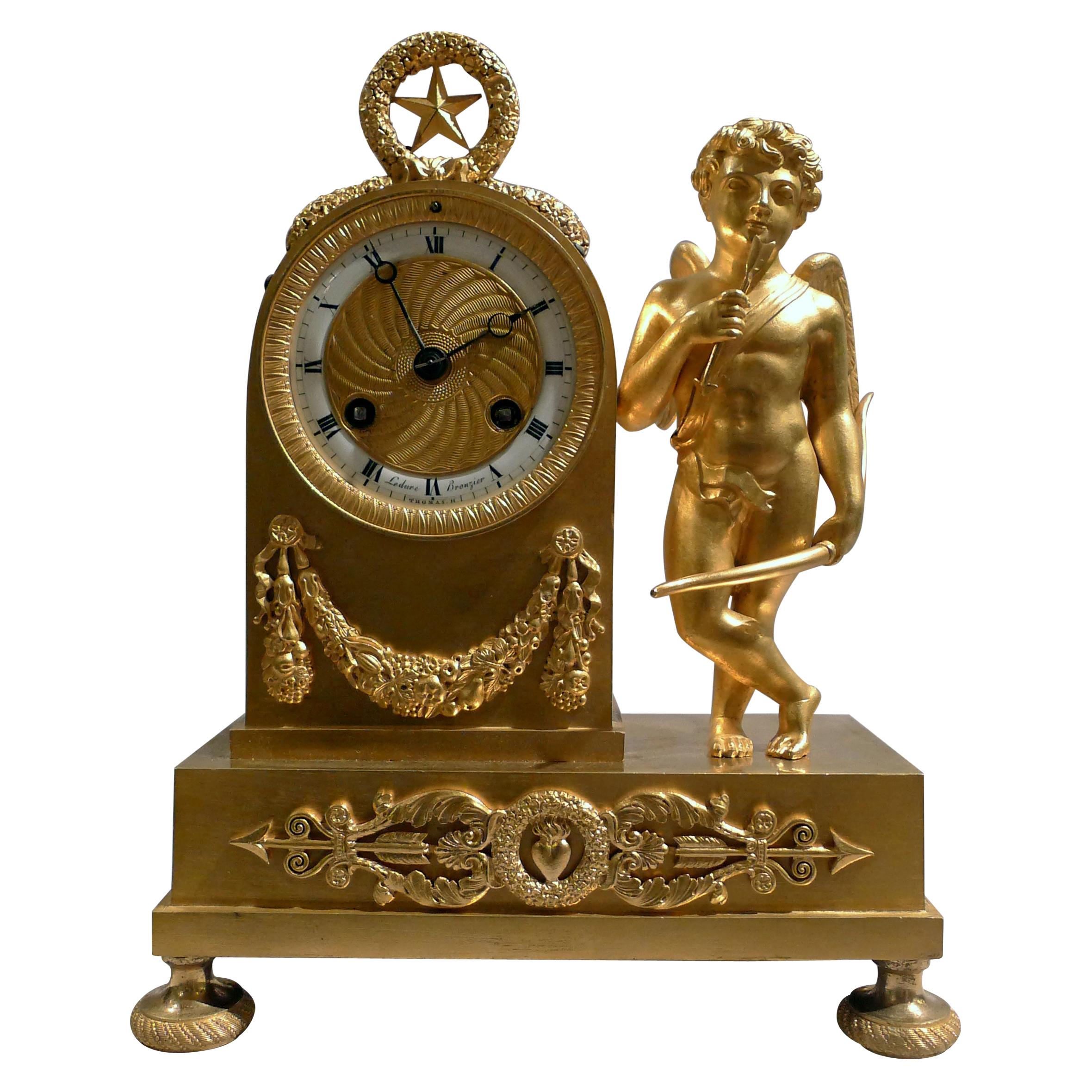 Pendule Empire miniature en bronze doré représentant Cupidon, signée par Ledure et Thomas