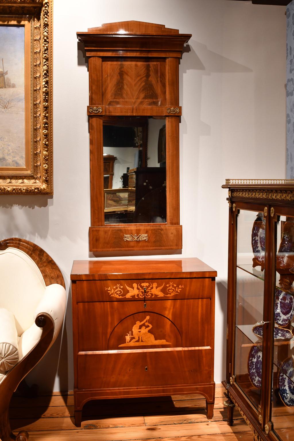 A very beautiful Empire mirror in fine West Indies/ Cuban mahogany with satinwood inlaid bandings. The book-matched figured mahogany draws the eye upward to the stepped pediment that graces the top of the mirror. Fine mounts of bronze d’ore ormolu