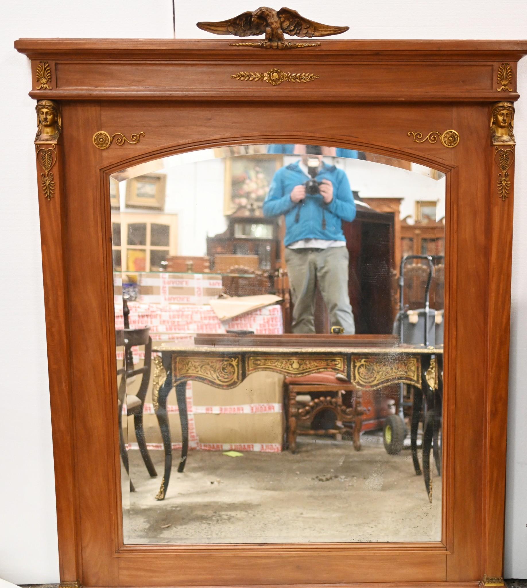 Elegant and refined French Empire overmantle mirror in satinwood
We date this work of art to circa 1840 
Good size at over six feet tall
Gilt fixtures are original and include the pharo head surmounted columns flanking the mirrors
Also acanthus leaf