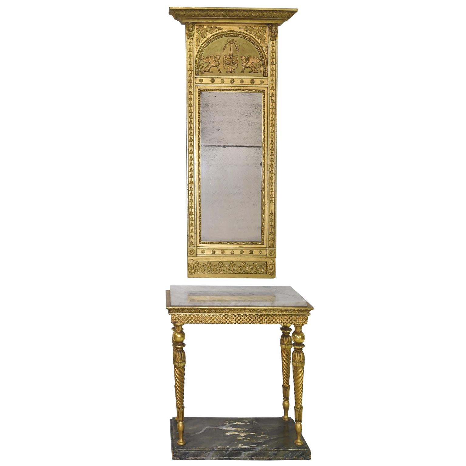 An early French Empire giltwood mirror decorated with the neoclassical motifs adopted during Napoleon's reign as French Emperor (1804-1814) and inspired by archaeological finds during his Egyptian Campaign. The cornice displays a row of palmettes