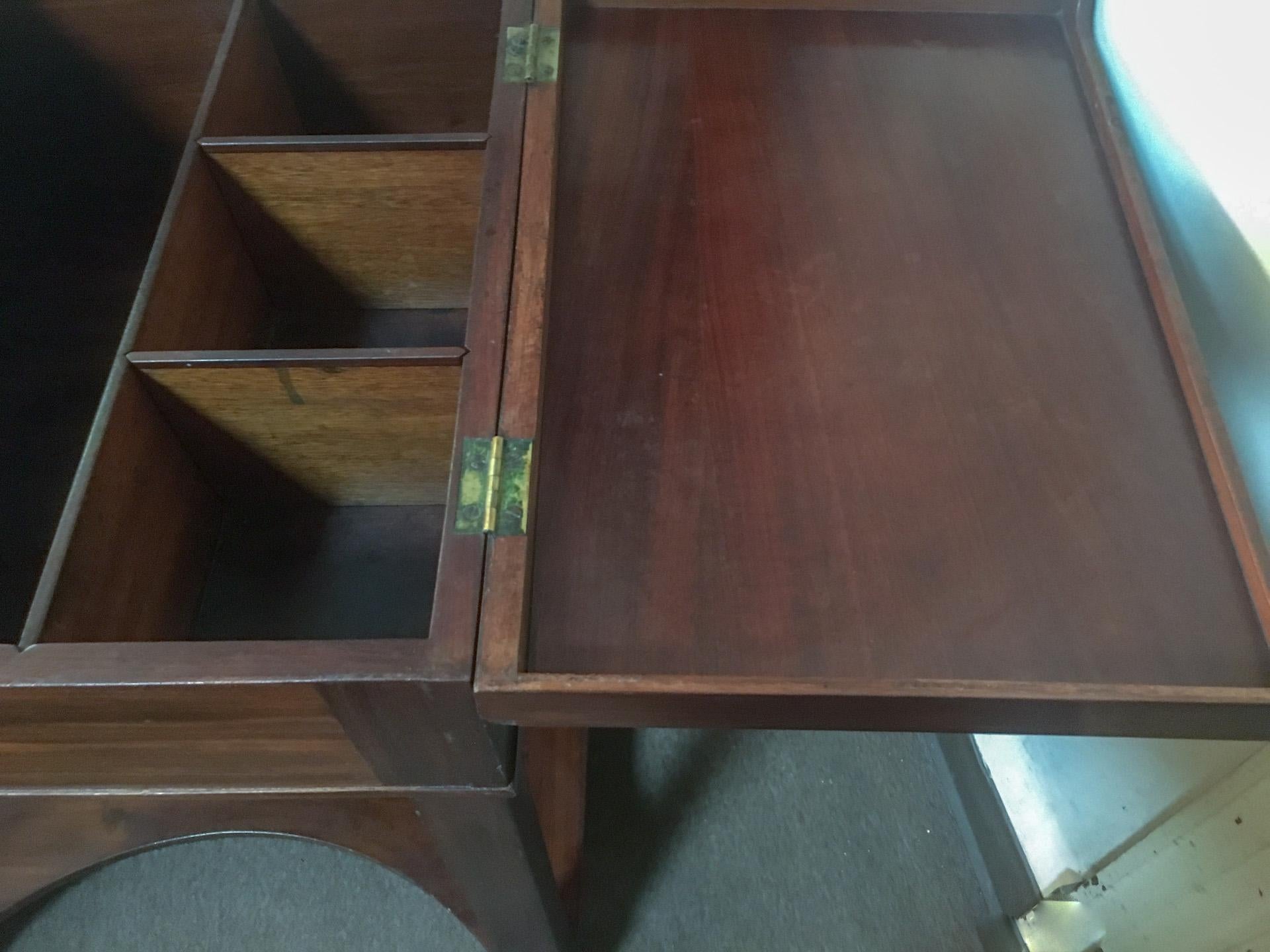 This handsome Napoleon III slightly rectangular mahogany side table with two flip tops doubles as a work or utility table with another curved shelf at the bottom. The inside features a large middle section, a long covered compartment with sliding