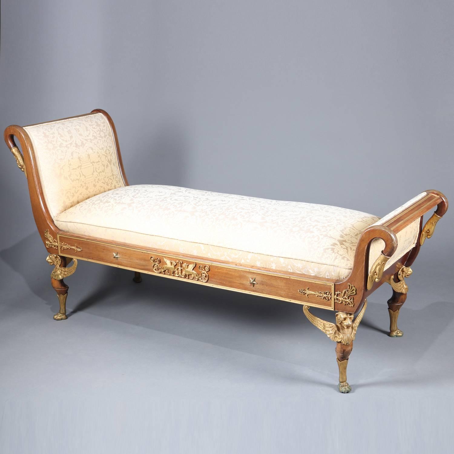 French Empire neoclassical mahogany recamier features mahogany frame with cast goose necks, griffin and star ormolu mounts, raised on legs with spread wing griffin supports and terminating in paw feet, upholstered seat, 19th century

Measures: 35