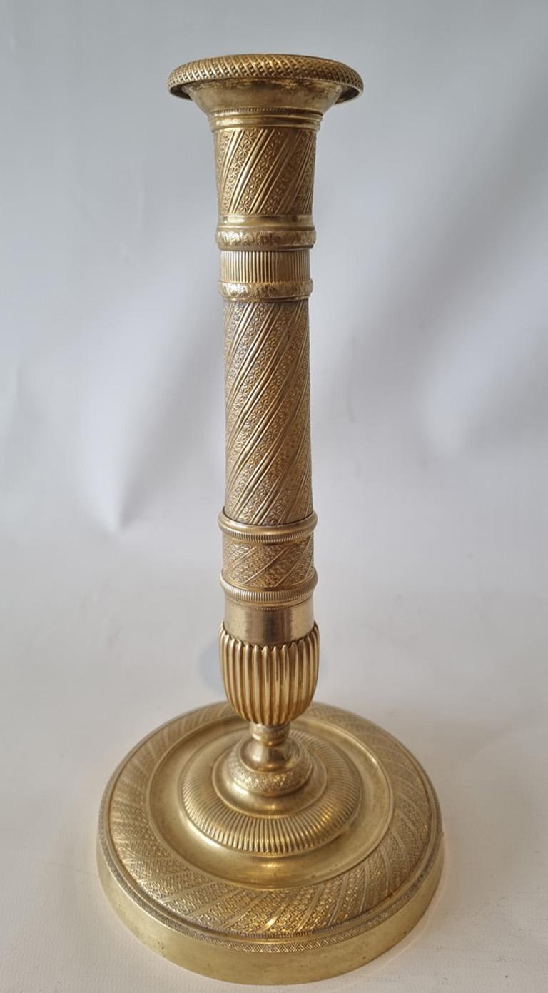 French Empire ormolu candlesticks of outstanding quality. Set on a circular base with unusually a decorated band around the top outside edge of the base comprising dots within diamonds. Within this is a gadrooned moulding leading to the domed foot