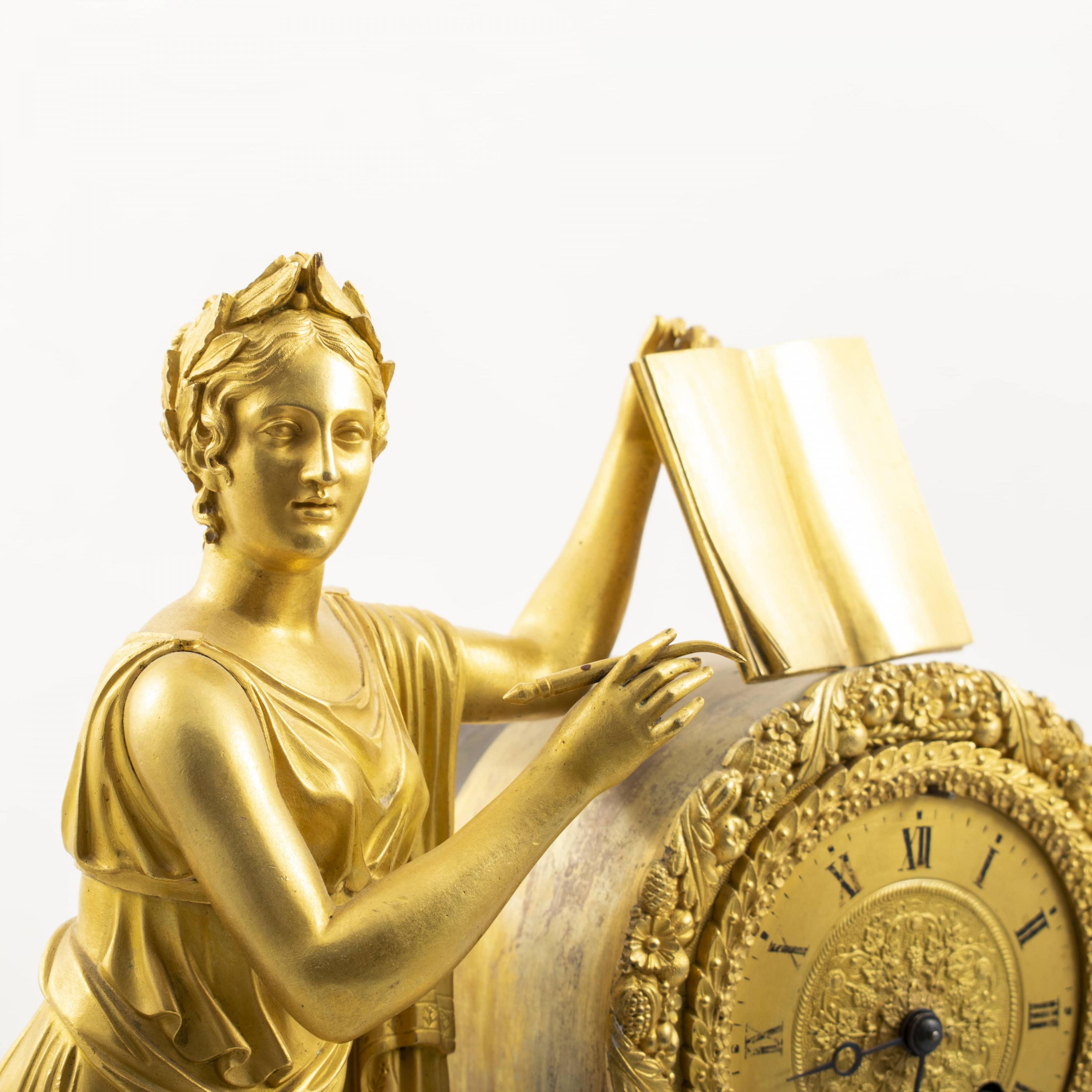 Large French Empire Ormolu clock.
Standing woman with pen and book.
Clock wreath with chiseled flowers and foliage.
Furthermore rich decorated with putties, busts of Socrates, etc.
France 1810 - 1820.

Excellent quality.