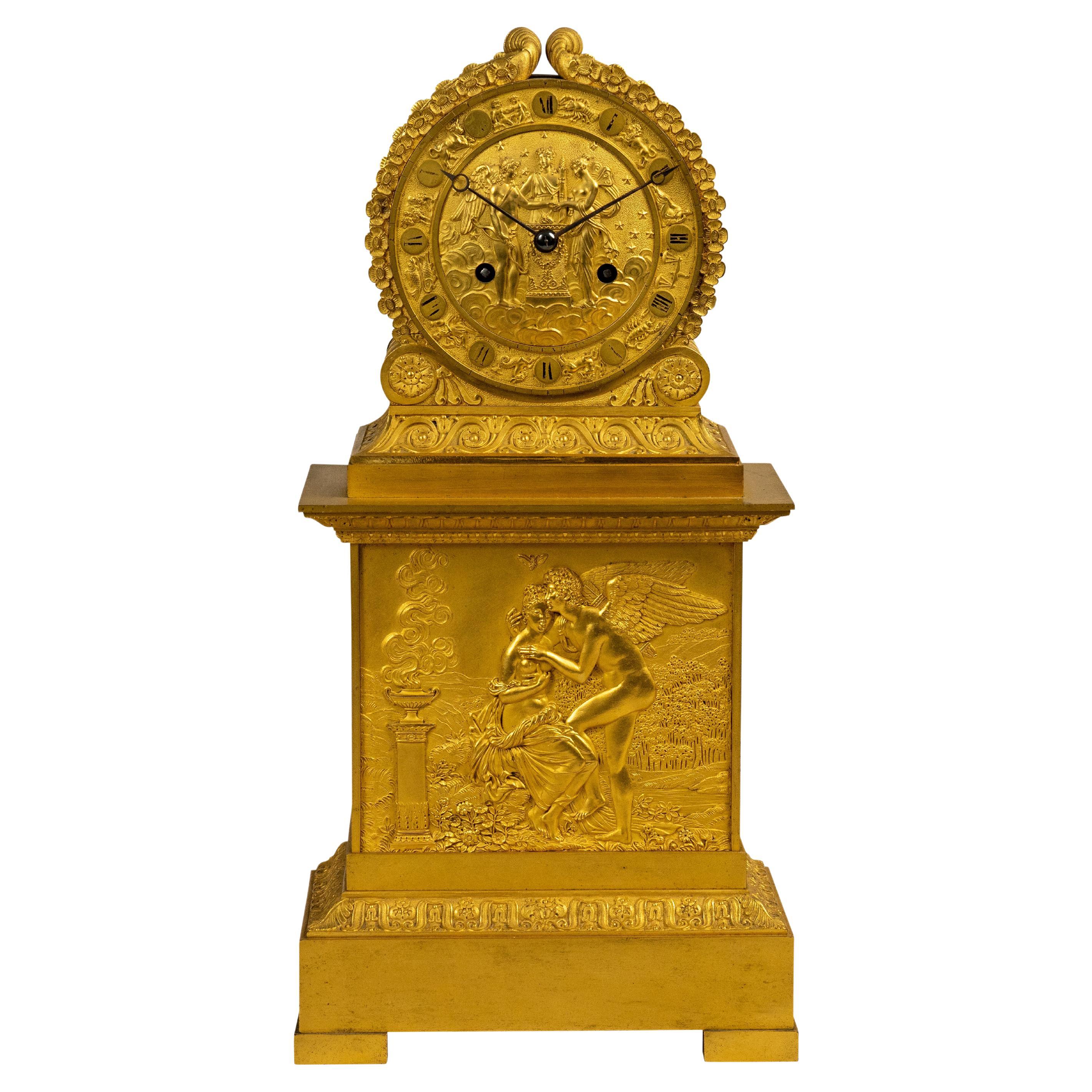 Pendule de cheminée Empire français en bronze doré représentant Cupidon et Psyché