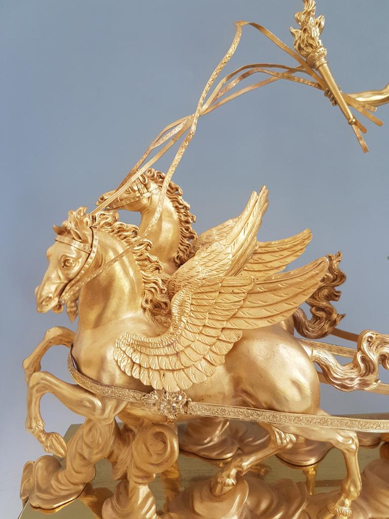 Français Pendule de cheminée Empire française en bronze doré représentant Aurore dans son char tiré par ses ailes en vente