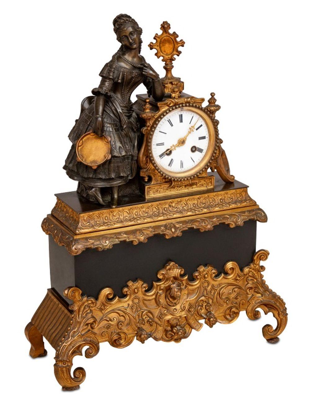 French Empire Patinated and Gilt Metal Figural Clock, circa 1840, surmounted by a seated female musician holding a tambourine, white enamel dial, strike on bell, on a gothic strapwork mounted black marble base. 17