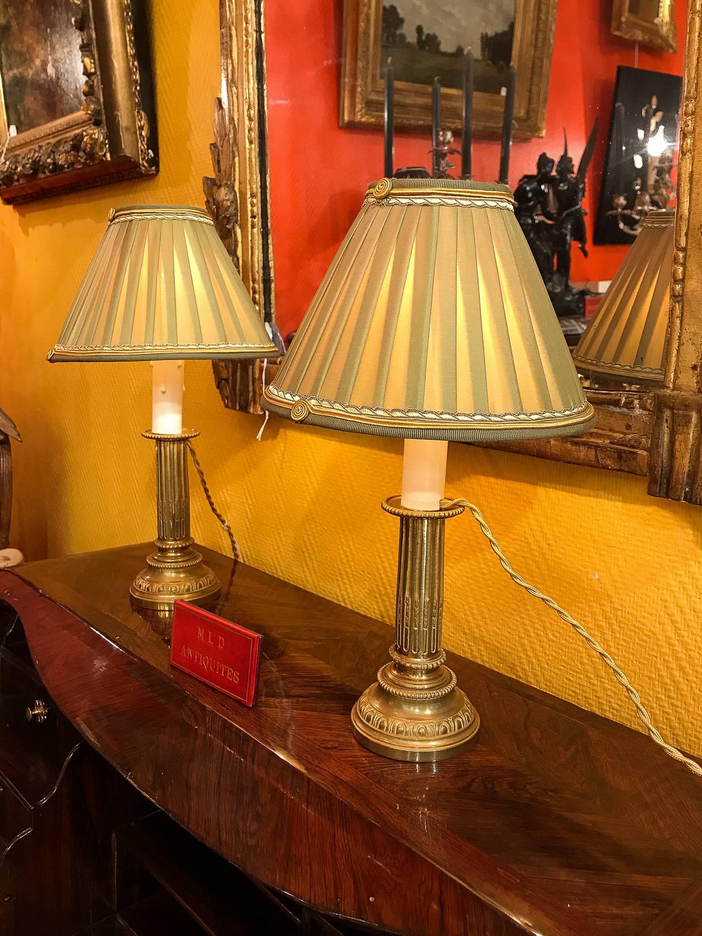 We are pleased to present you a lovely pair of French Empire period, original gilt-bronze candlesticks, very finely chiseled, converted to table lamps, with new French pleated silk lamp shades, celadon color.

French work early-19th century,