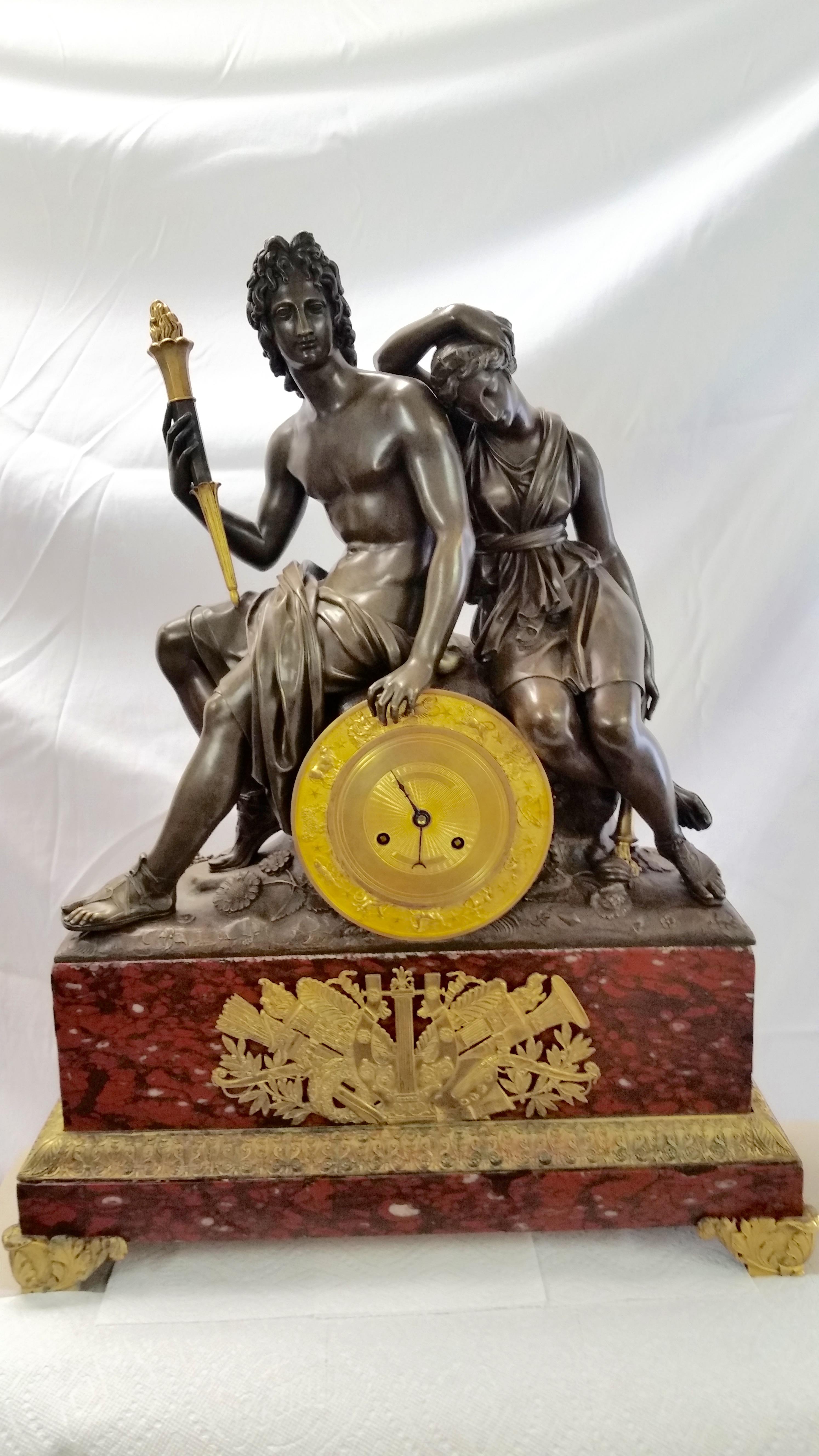 Exceptional French Empire period bronze and red Languedoc marble clock of the highest quality. Fantastic casting details down to the toe nails. Retains original patina to bronze and doré finished portions. Clock movement appears to be original and