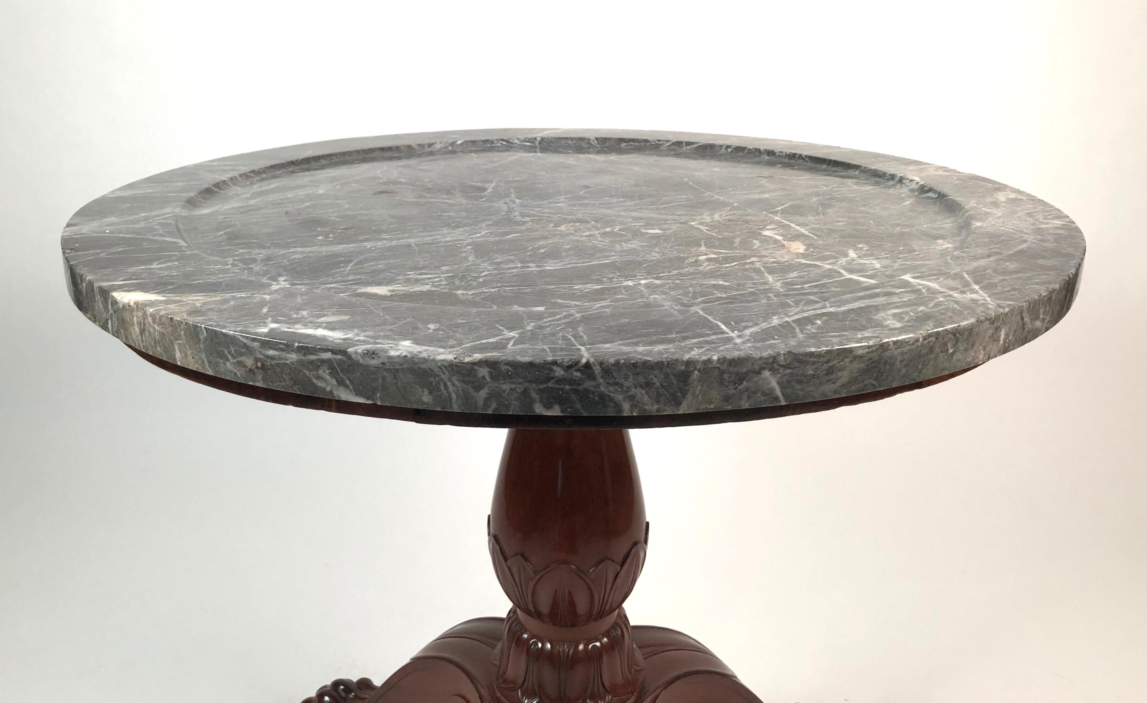 A fine quality, wonderfully bold and well proportioned French Empire period table with carved marble top over a baluster-form pedestal with finely carved lotus leaves over a tripod base with carved lotus leaves and boldly carved animal paw feet. The