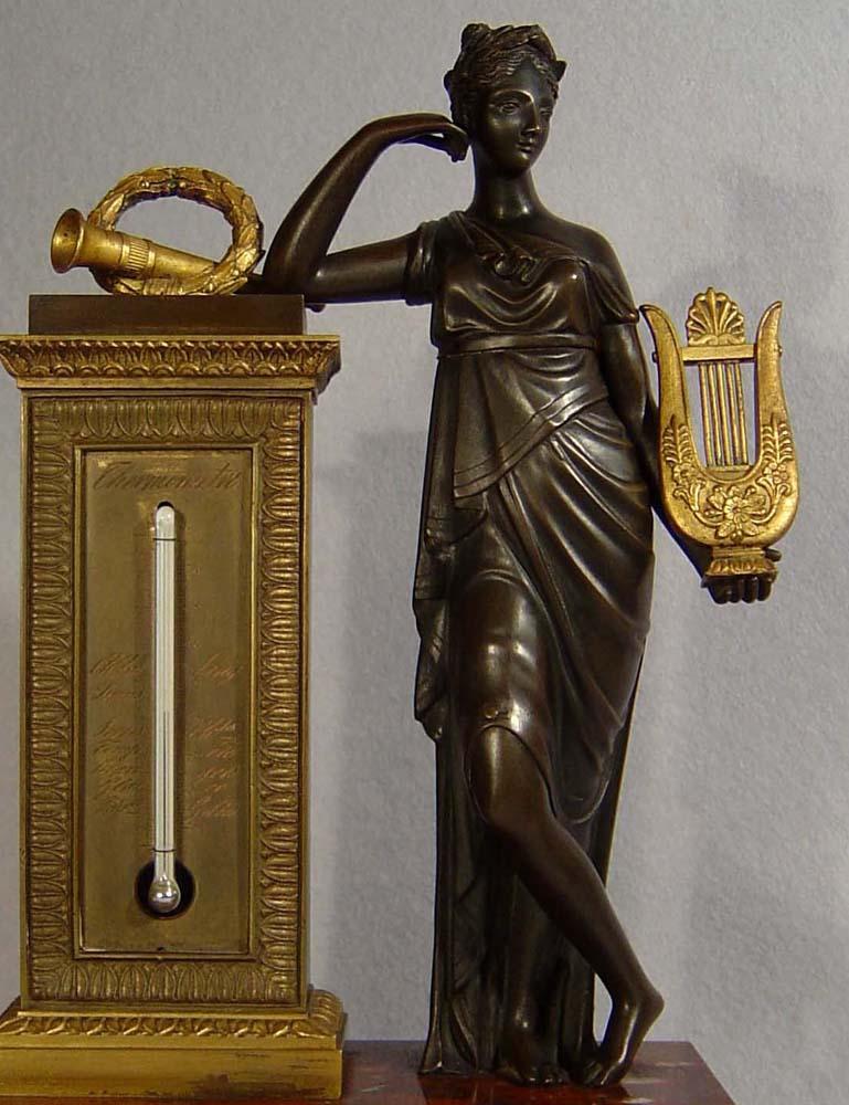 A very fine antique French Empire period figural thermometer of patinated bronze, ormolu and rouge marble. The rectangular red marble base with four ormolu winged paw feet. The figure of Sapho to the right of the thermometer is beautifully cast and