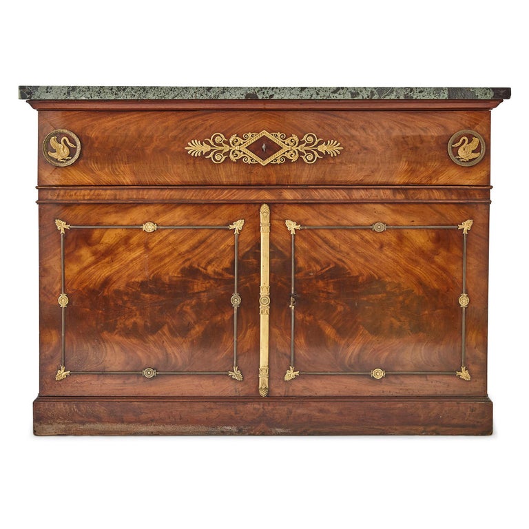 This beautiful mahogany cabinet was crafted in France in the early 19th century, when Napoleon Bonaparte was Emperor (1804-1814,15). The cabinet features a wide rectangular body, topped by flecked light green marble. Its body is split into an upper
