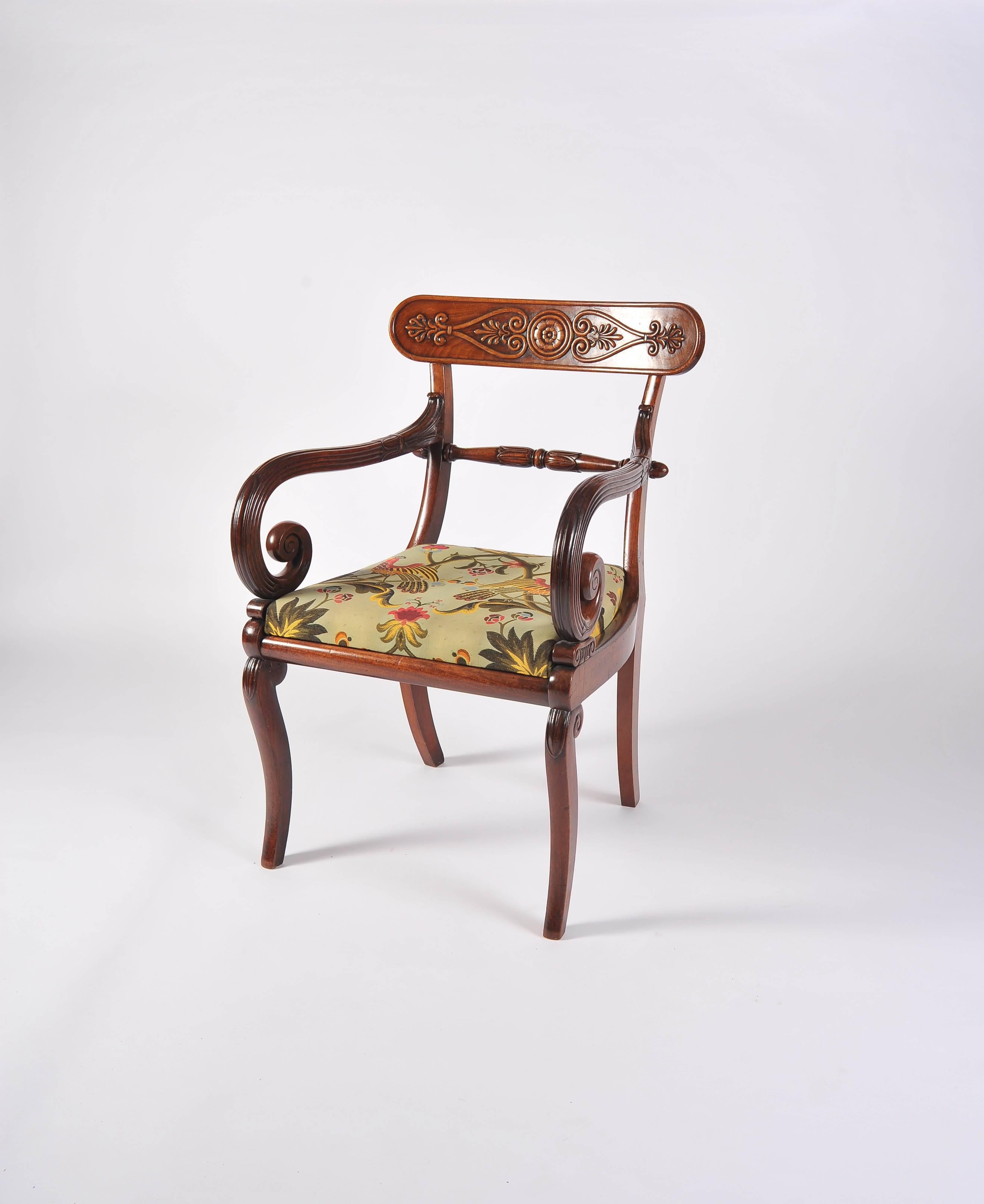 The drop in seat below a beautifully carved top splat and turned central rail with finials, the reeded and decorated scroll arms resting on stylized capitols on the polished seat rails; standing on scroll cabriole legs to the front and splay to the