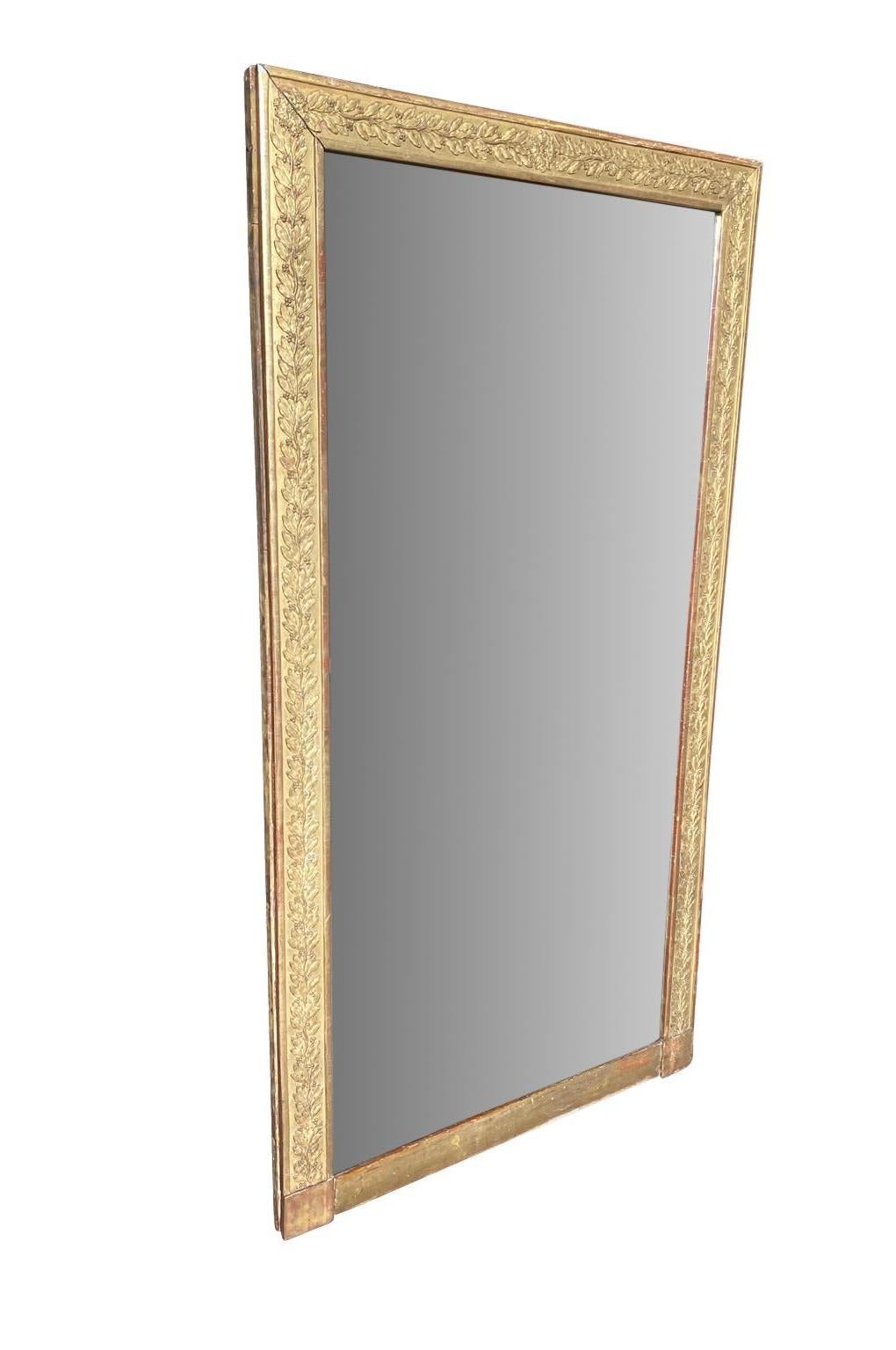 A very lovely French Empire period mirror in gilt wood with a wonderful floral motif. The mirror retains its original mercury glass and is in 2 sections. Please see unphoto shopped photos.