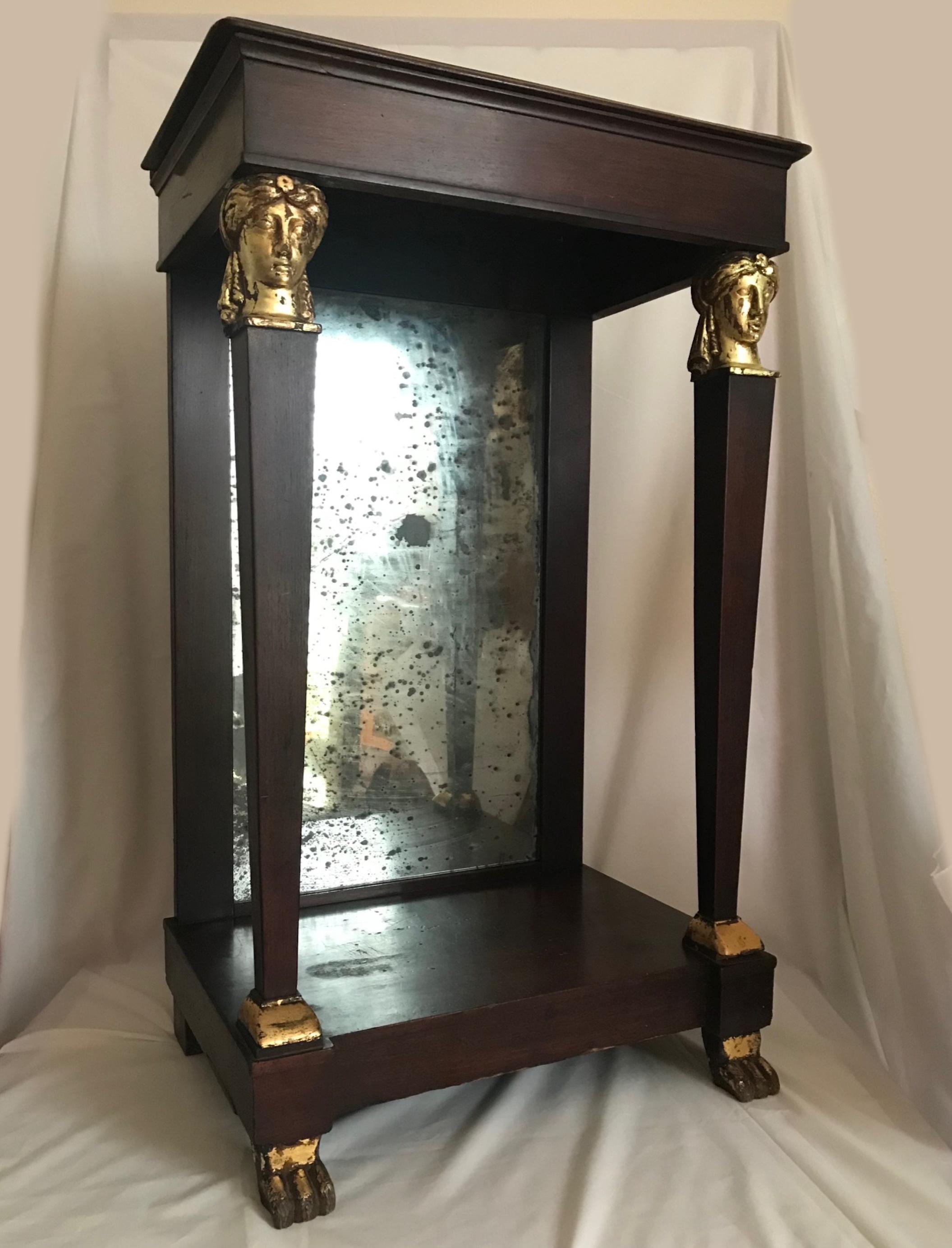 French Empire period petite mahogany console with mirror, circa 1810.

Original French early Empire period petite mahogany console with back mirror. The console is characterized by a pair of tapered columns with wood carved and gilded classical
