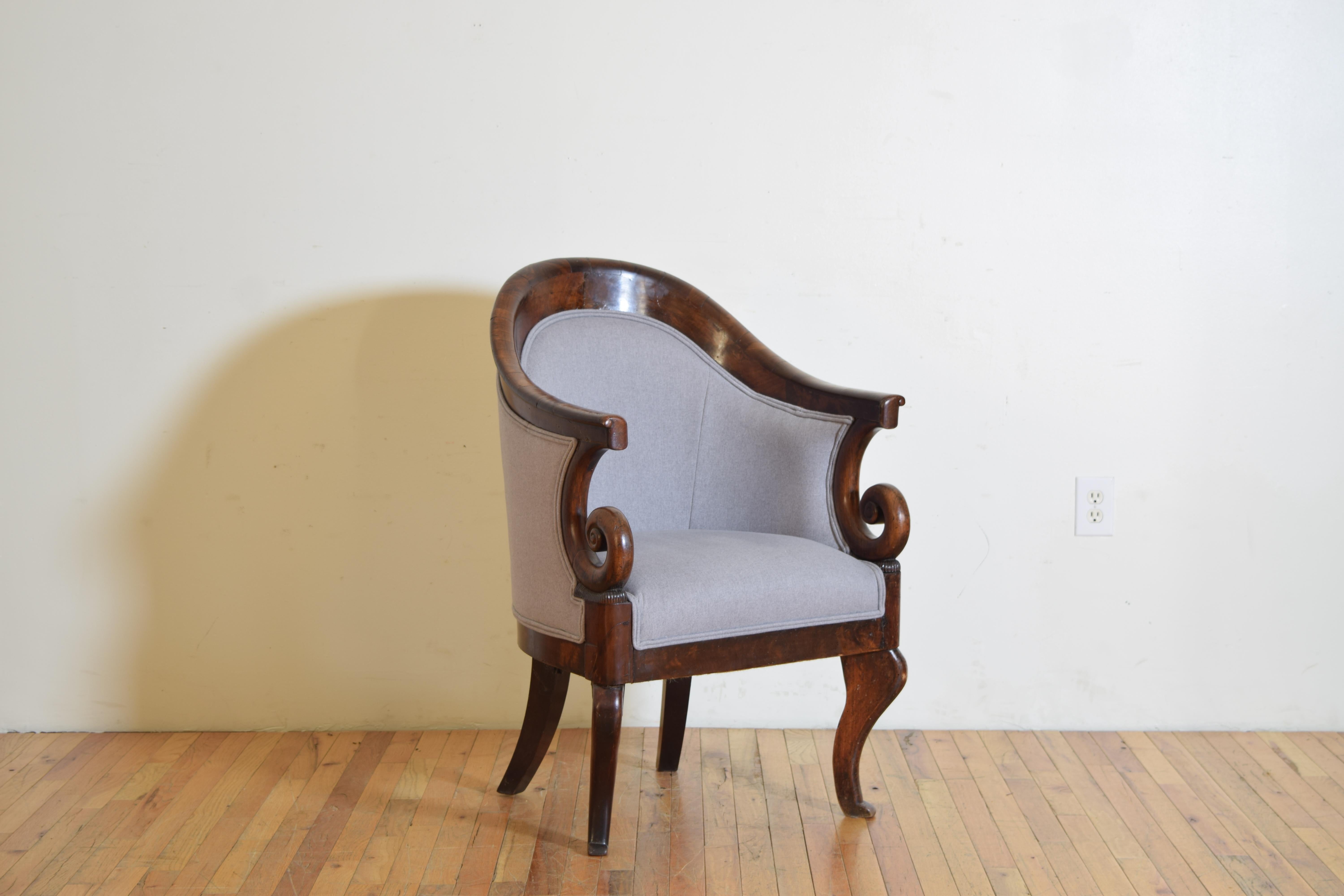 having a concave and arched backrest, the with shaped open armrests allowing a sword and scabbard to remain on the sitter, raised on carbriole legs, the inside of legs with antique iron bracing, newly upholstered in light grey wool
