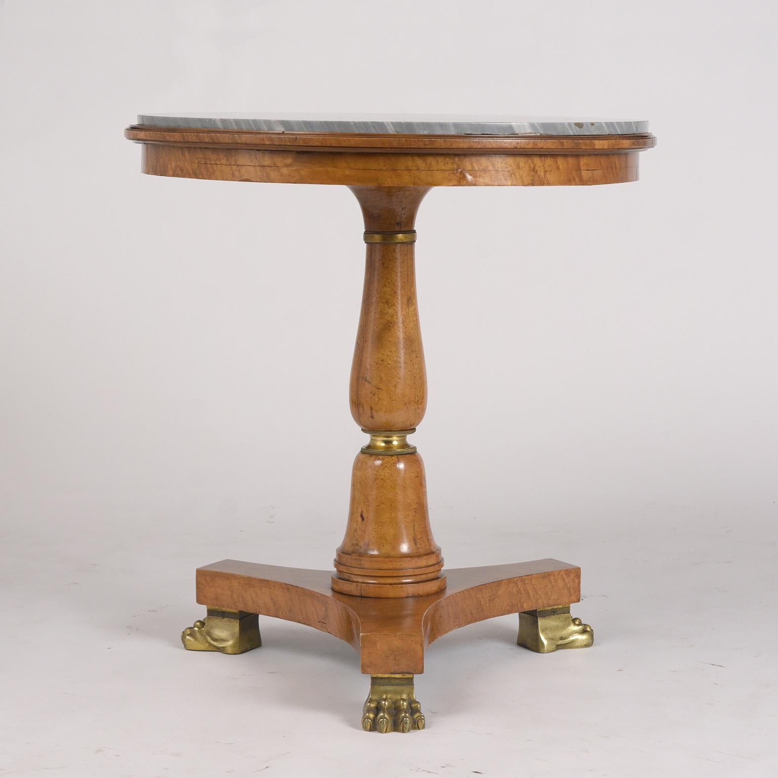 This French Empire Style Side Table is Circa 1830's and is made out of maple and birch wood combination stained in its original walnut color with waxed & polished finish. The Gueridon features the original round grey colored marble top with white
