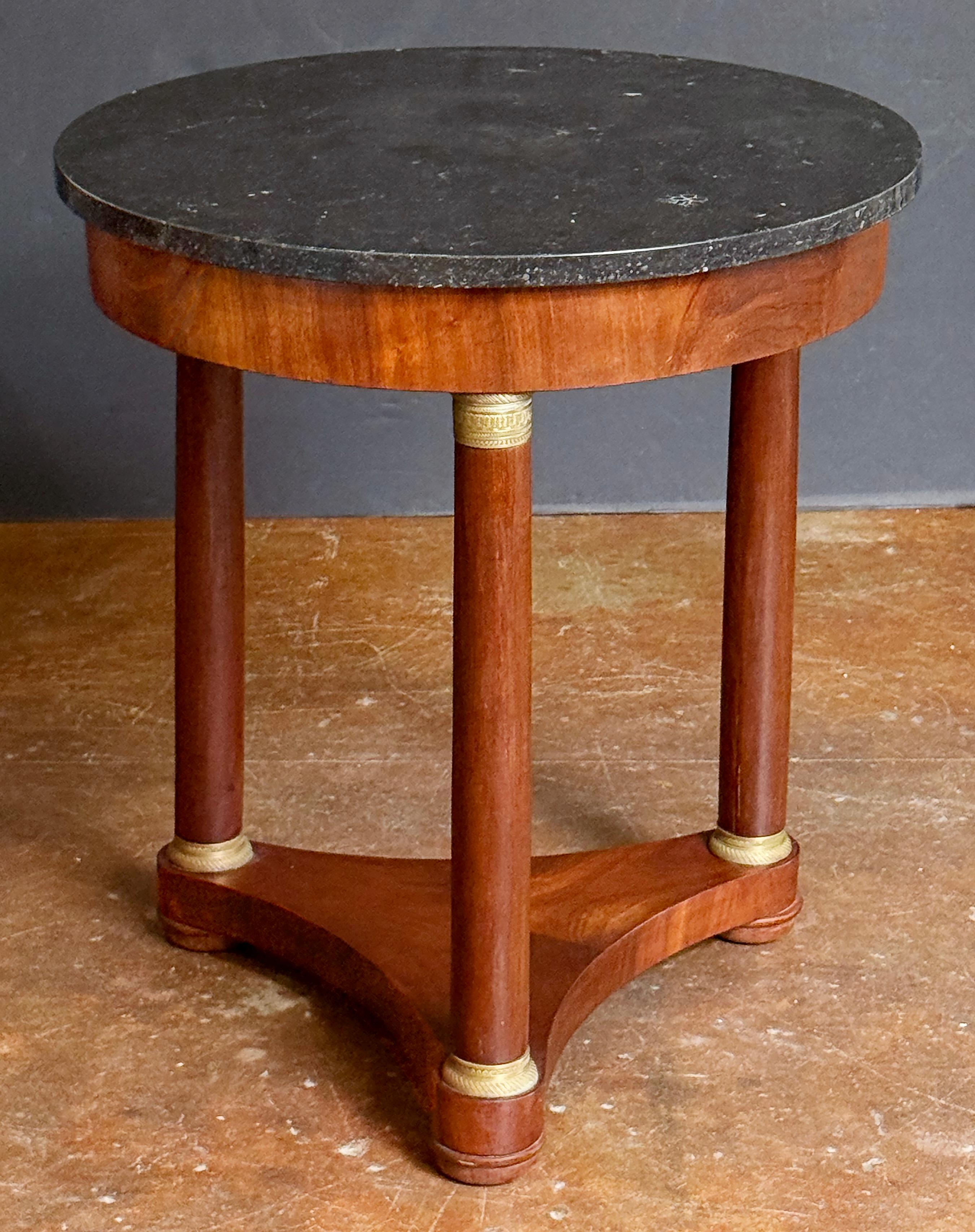 Une belle table ronde française ou guéridon de style Empire, avec un plateau circulaire en marbre noir figuré (25,5