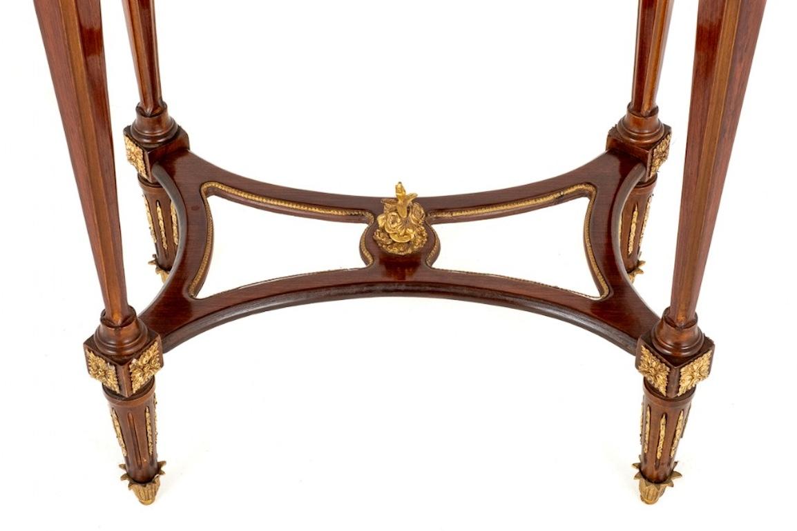 Ornate French rosewood occasional table.
The top of the table being of a shaped form with floral marquetry inlays. The table stands upon square tapered legs and a shaped stretcher. The whole of the table having wonderful ormolu mounts and moldings.