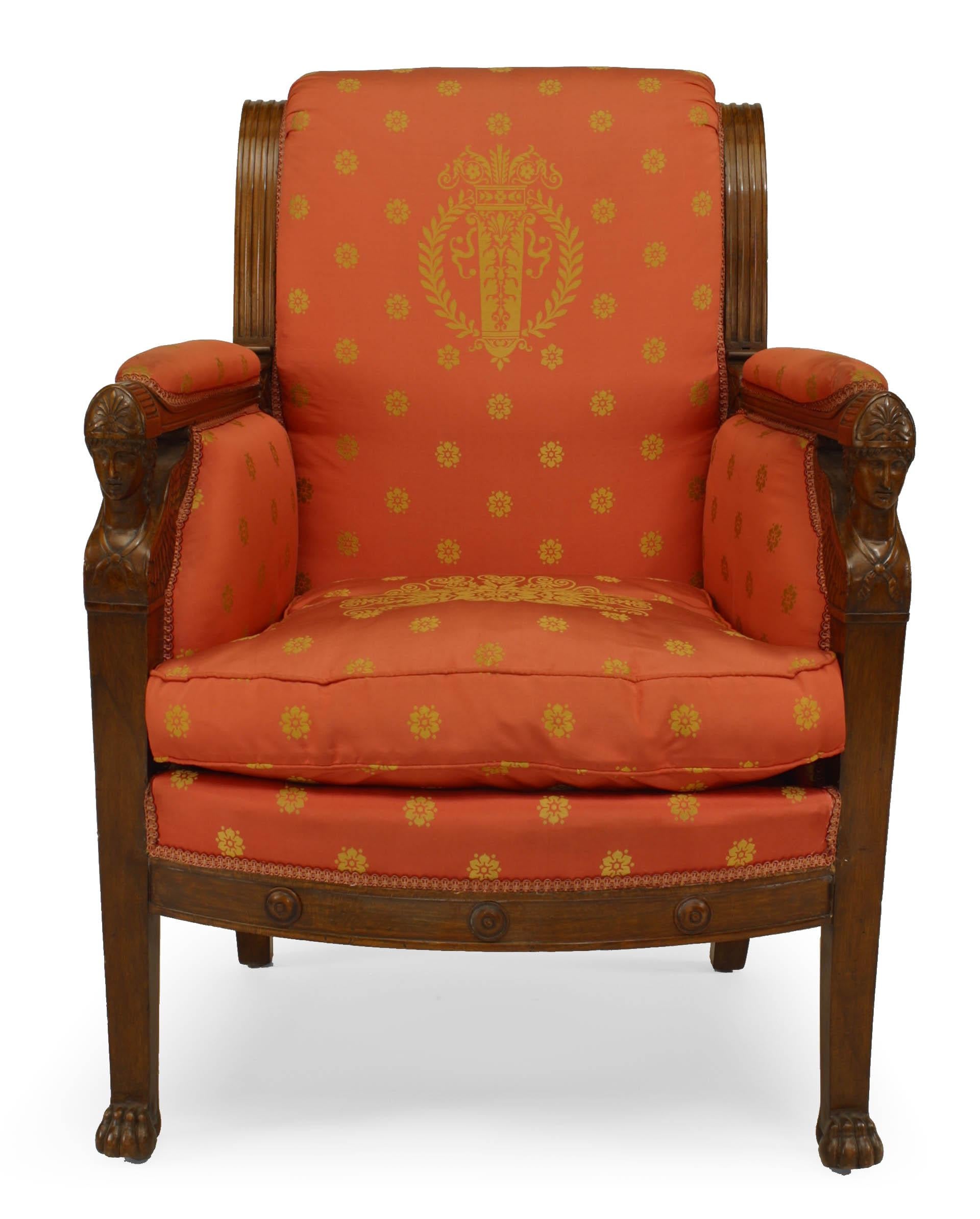 Pair of French Empire mahogany bergère (armchairs) upholstered in red silk with scrolled back above winged caryatid arm uprights & a loose seat cushion, (early 19th century).