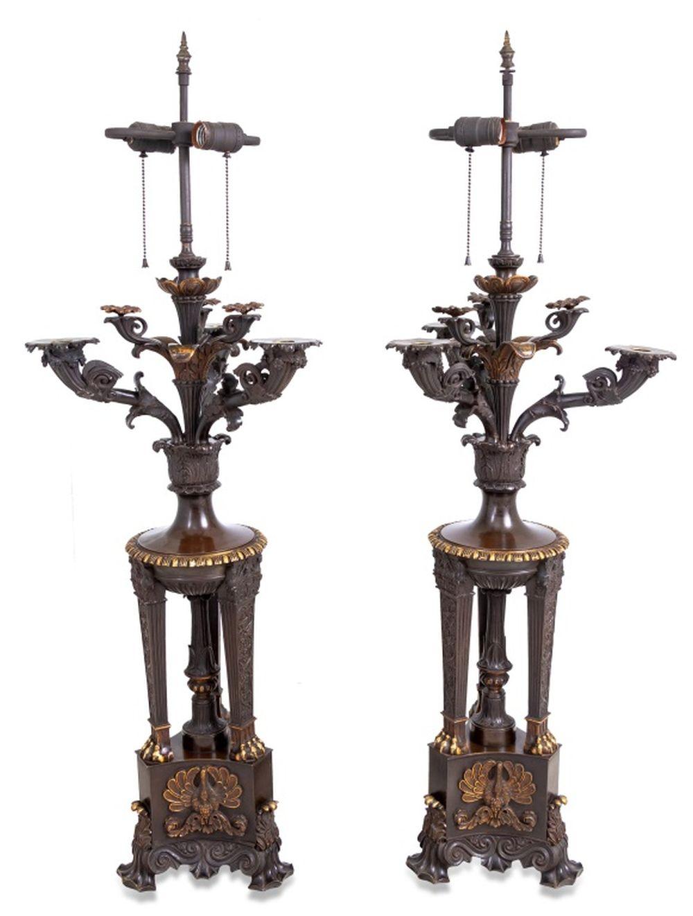 Coppia di candelabri a quattro rami in bronzo patinato stile Impero francese montati come lampade, dopo l'antiquariato, XIX secolo, ciascuno a forma di braciere, con rami foliati a volute, supporti a zampa di leone, su una base tripartita. In